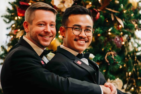 two grooms in front of a Christmas tree