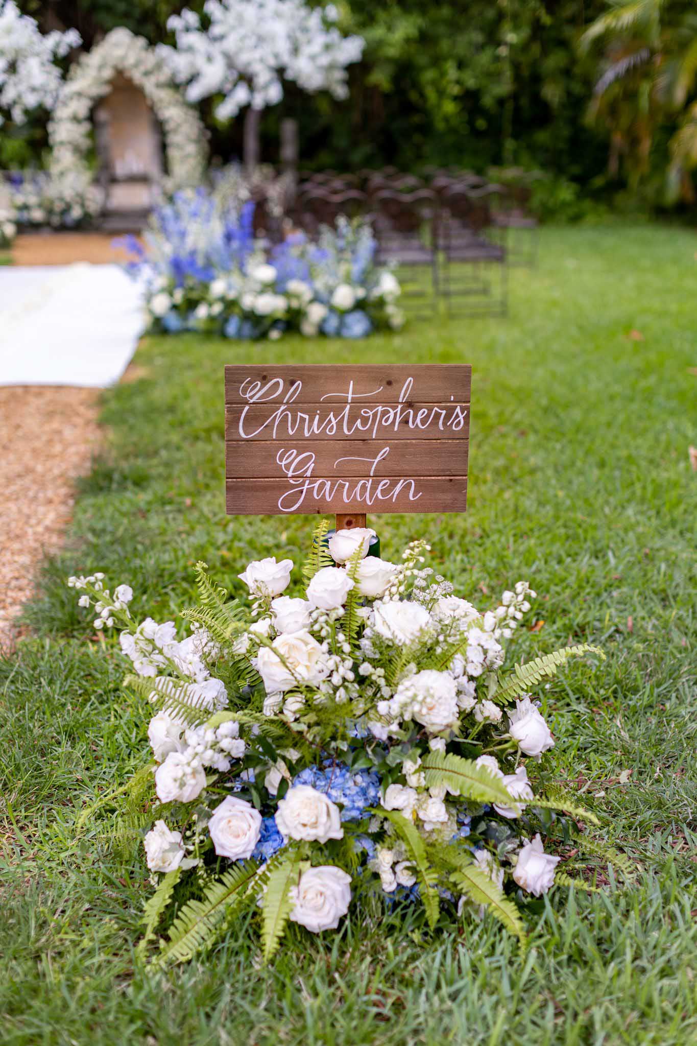 wooden sign Christopher's Garden and white and blue flowers