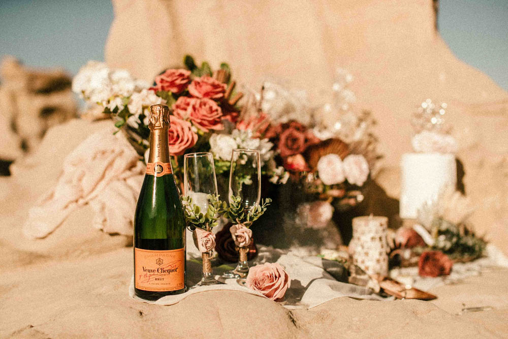Veuve Clicquot and champagne glasses in desert for wedding