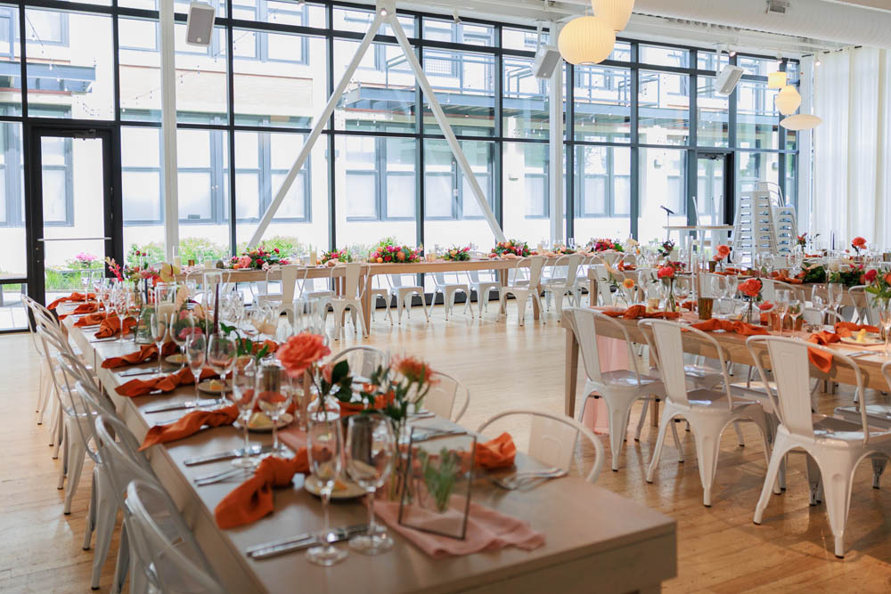 wedding reception table with shades of orange linens and flowers