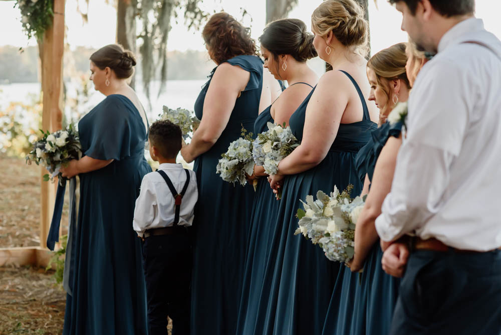 wedding party bows their heads to pray during lesbian Christian wedding