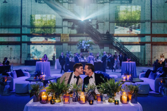 Two grooms kiss at reception