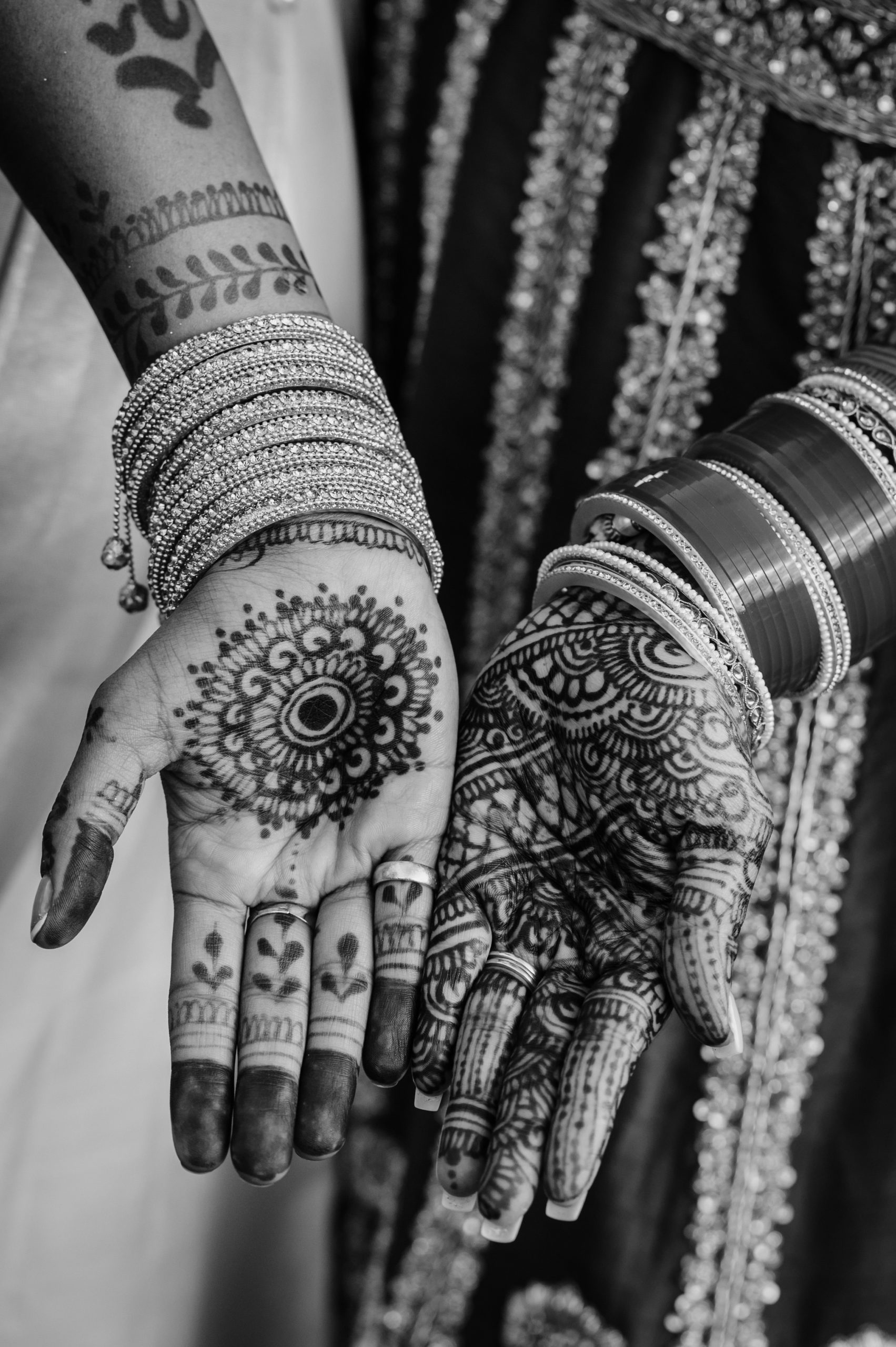 A black-and-white photo of traditional wedding henna on the hands of the celebrants.