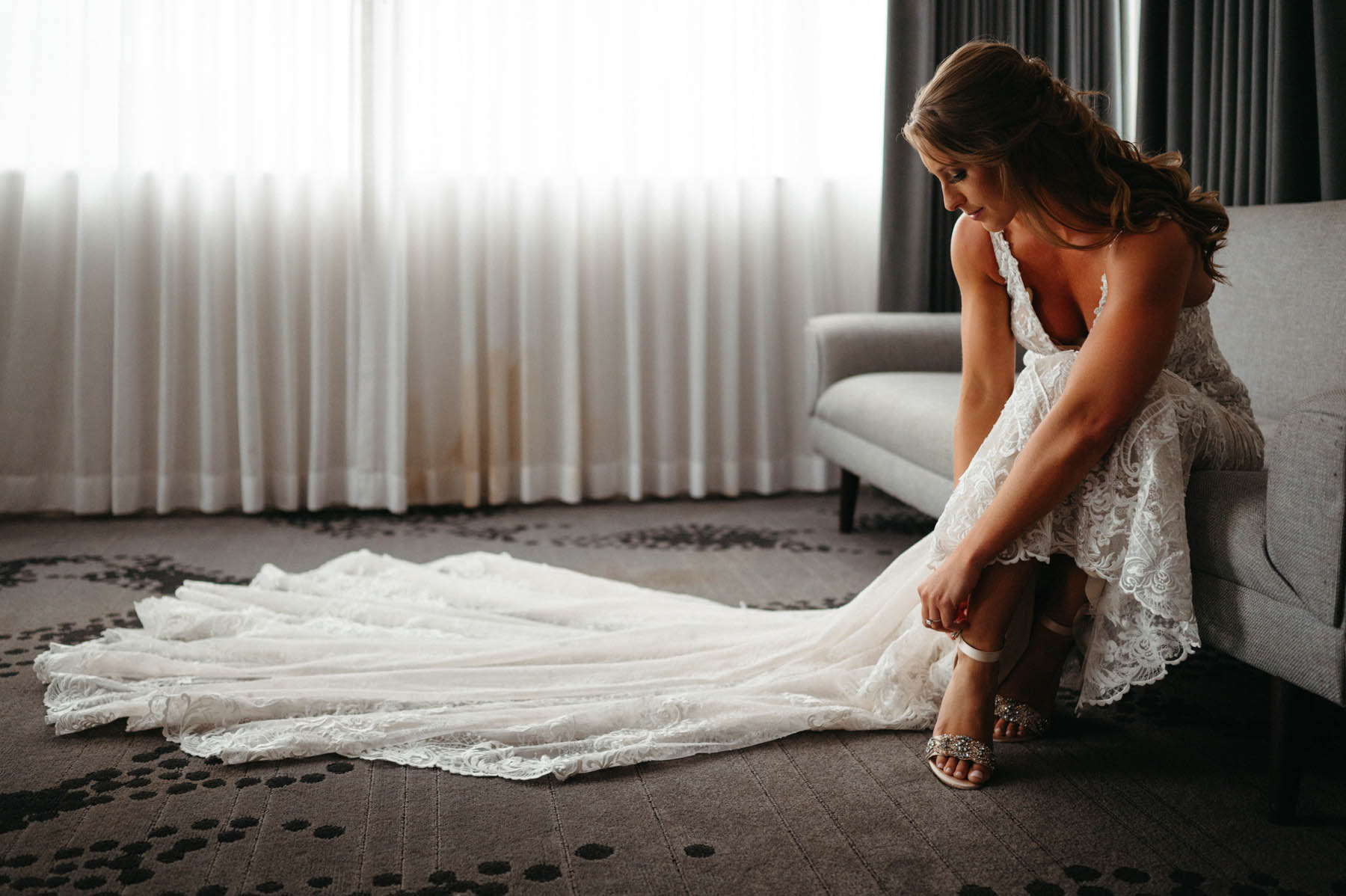 One of the brides poses as she buckles her shoe.