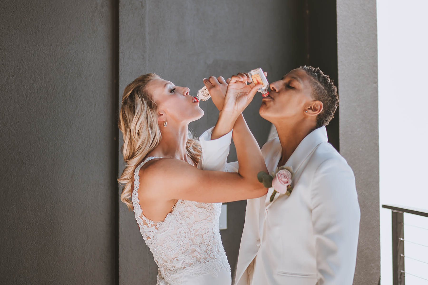 The marriers, dressed in all white, intertwine their arms as they take shots of Fireball.