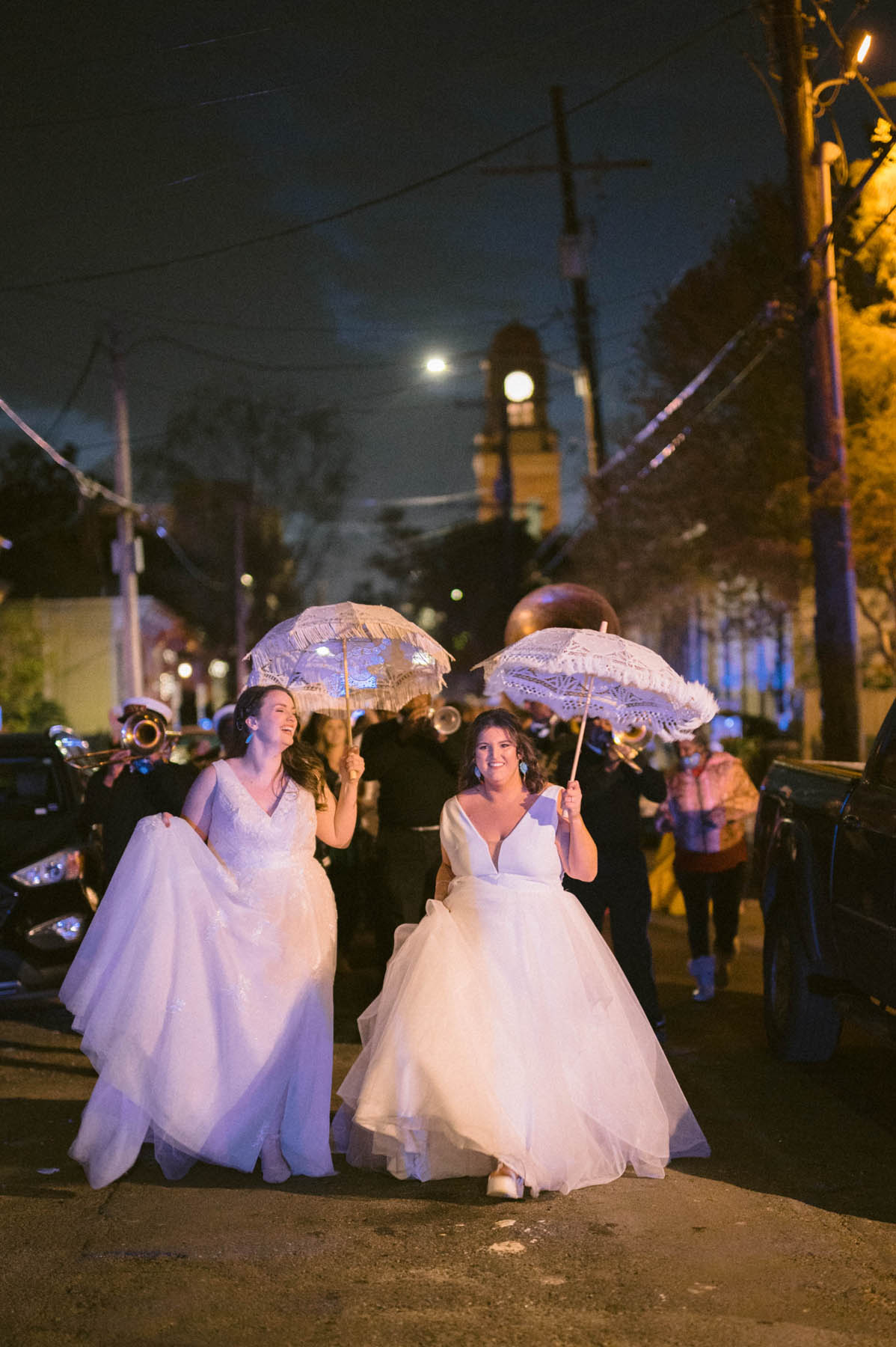 The newlyweds walk in front of a brass band through the trees of NOLA.