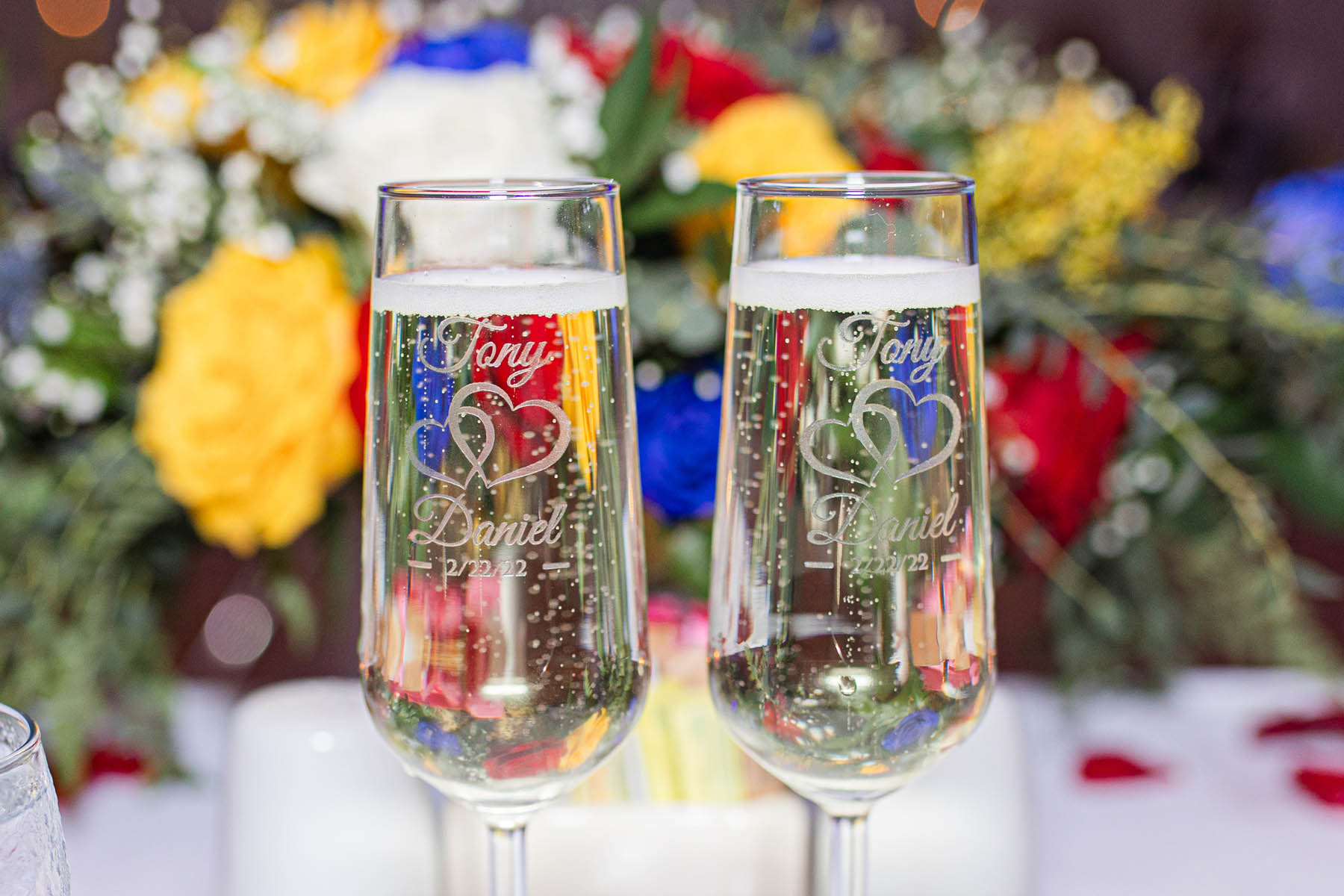 Two custom champagne glutes, engraved with the names Tony and Daniel and their wedding date.