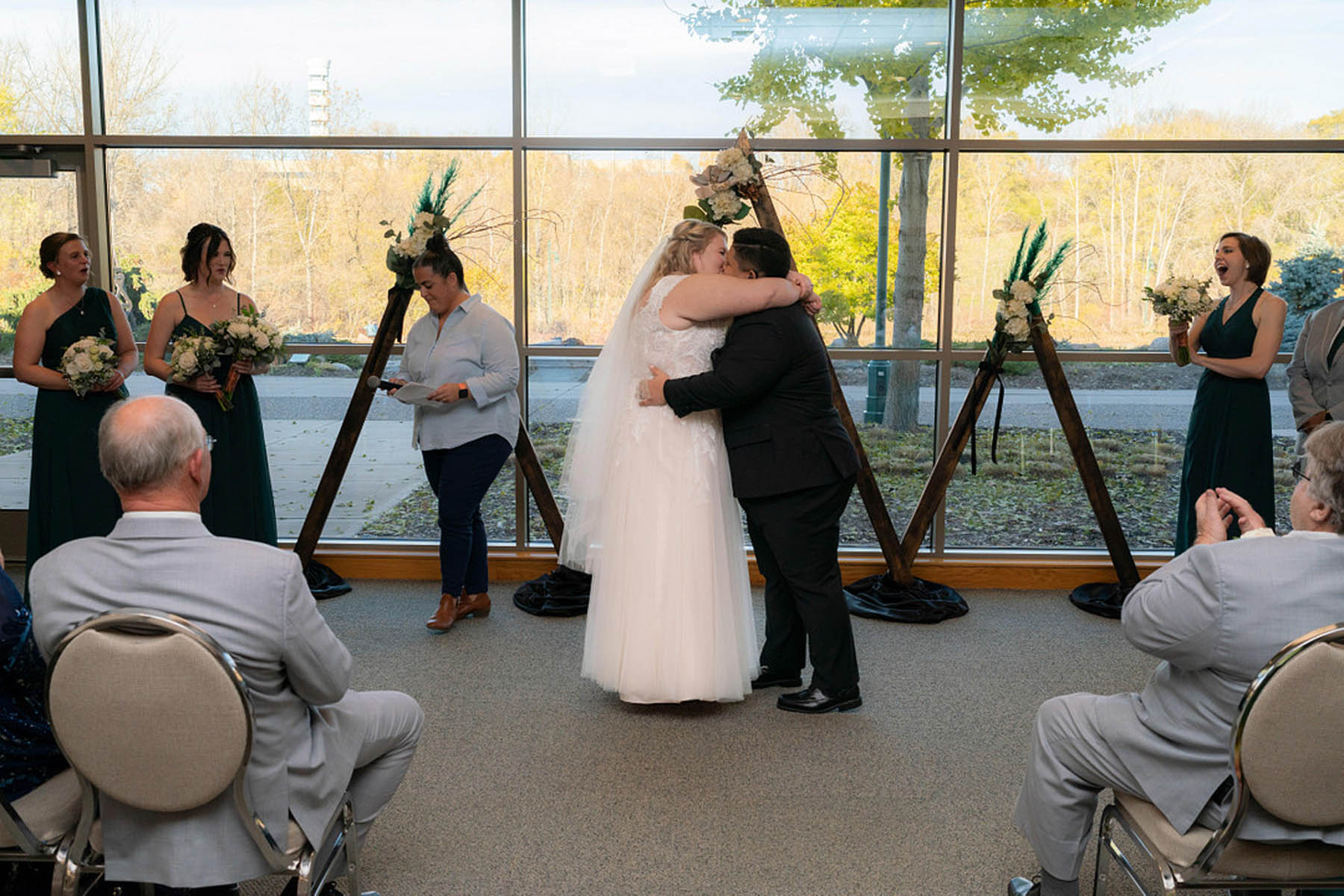Two brides embrace as they share their first kiss as newlyweds
