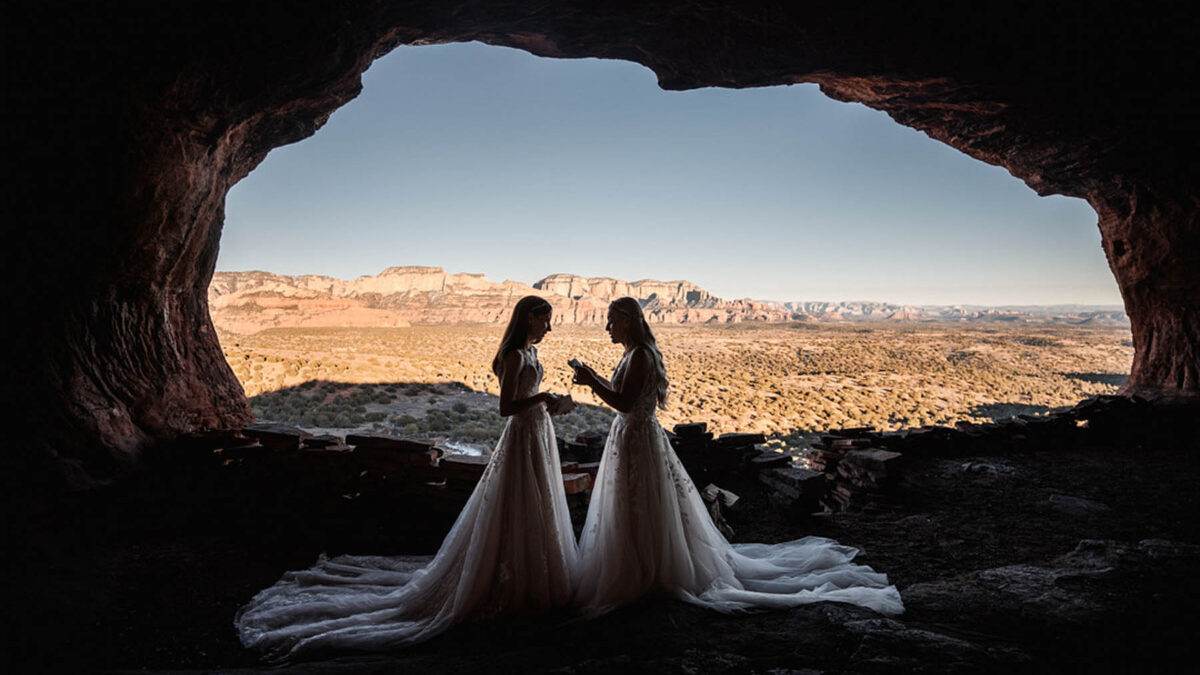 A hidden cave desert elopement in Sedona, Arizona, with matching vow books, lace gowns and a campfire