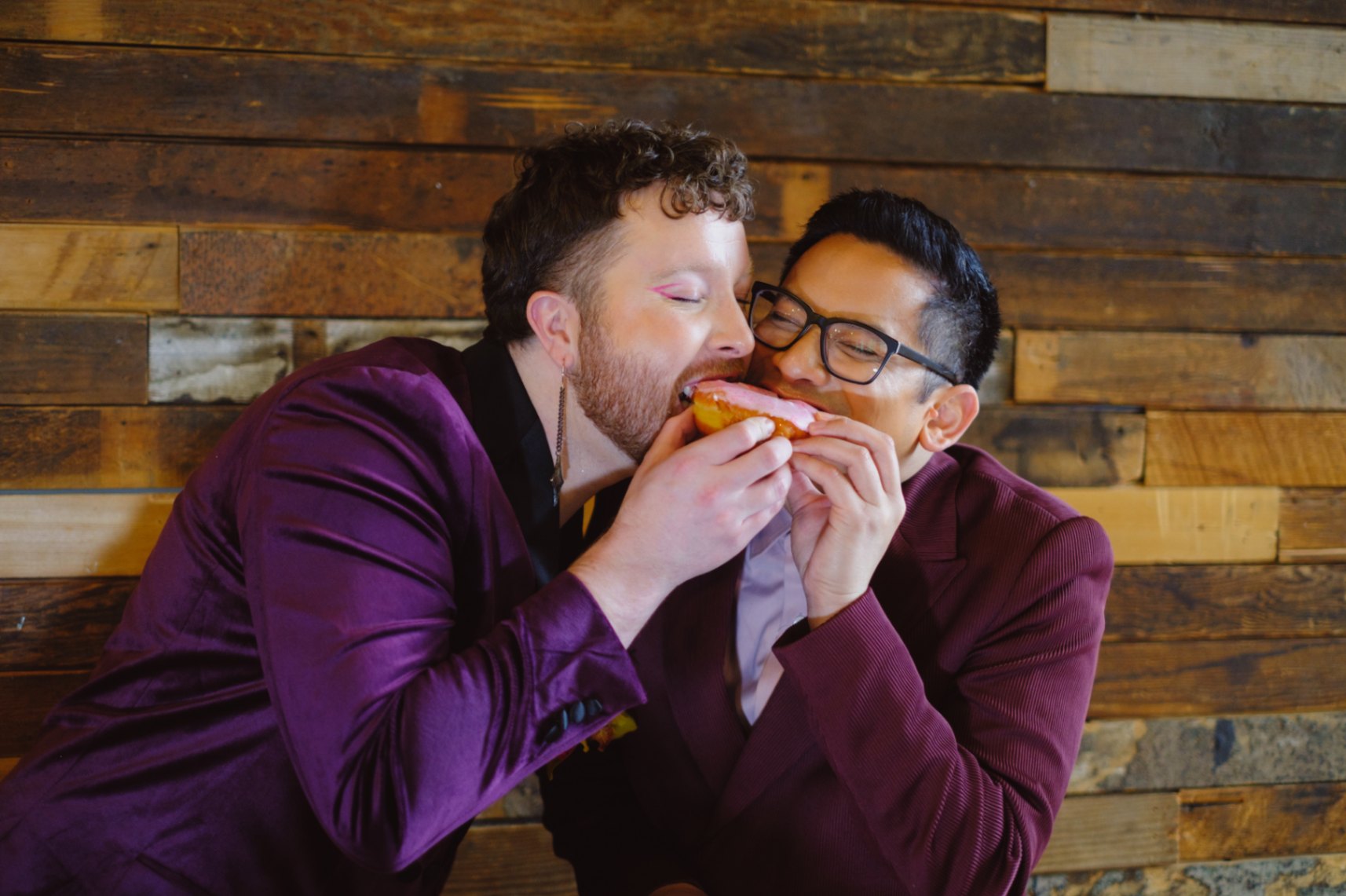 Nonbinary queer couple eats a donut together in Seattle