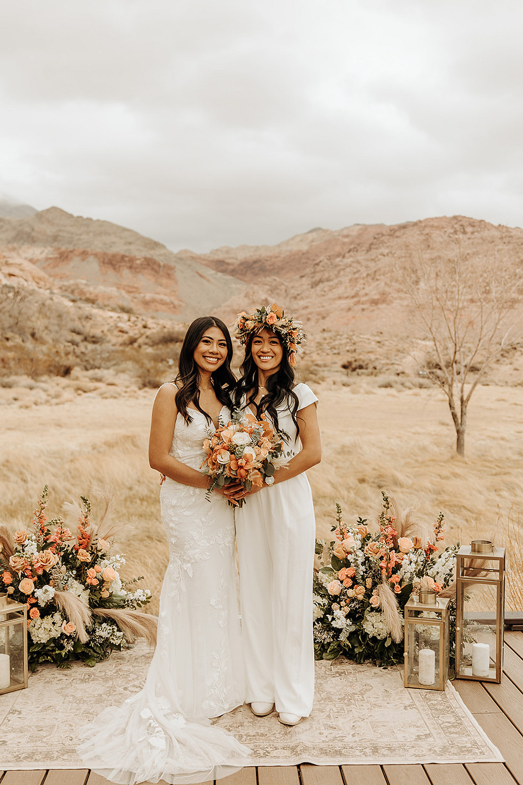 Lesbian brides hold hands and laugh at their intimate Red Rock Canyon elopement.