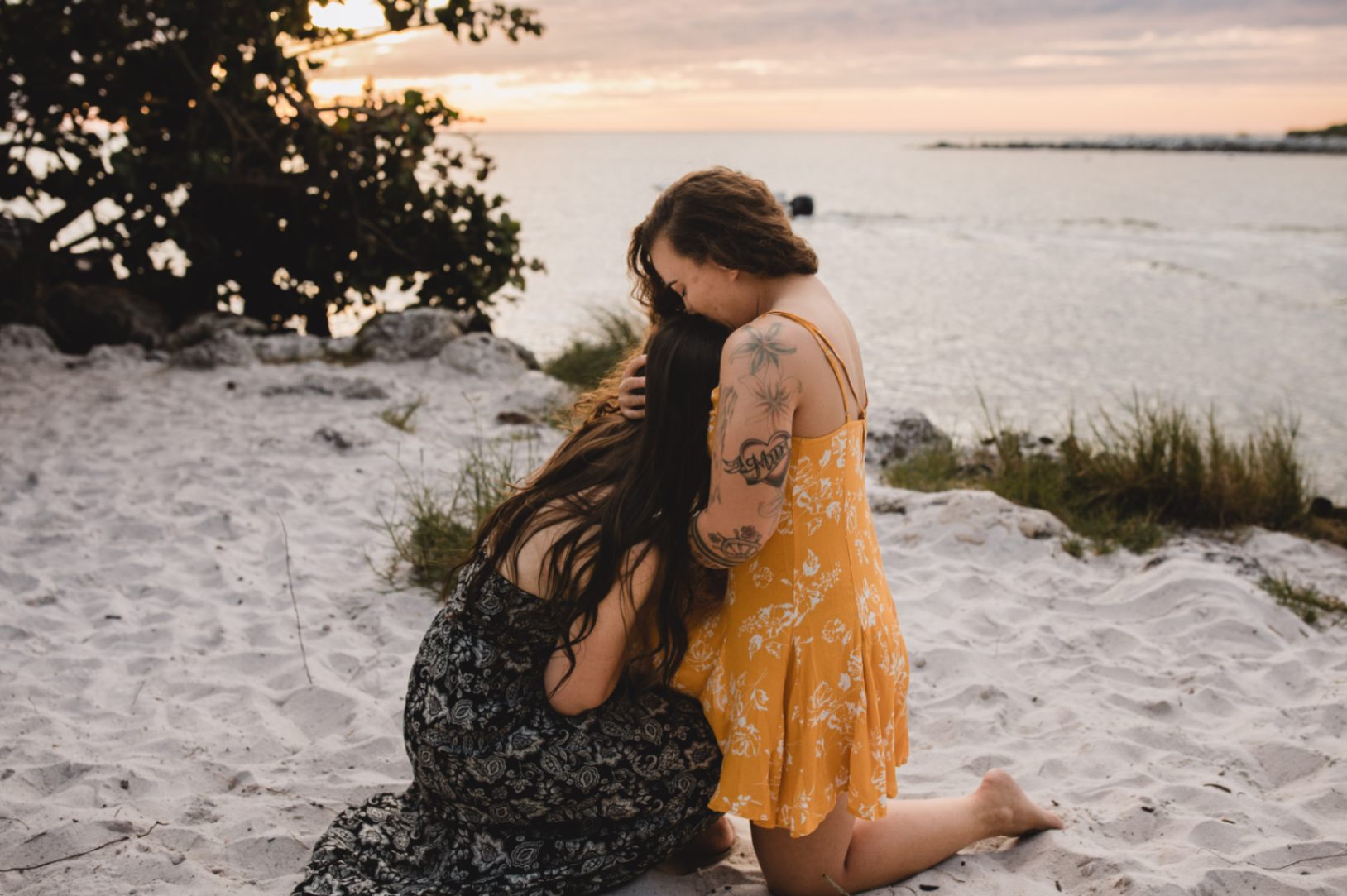 two women in love hug each other on the beach after getting engaged