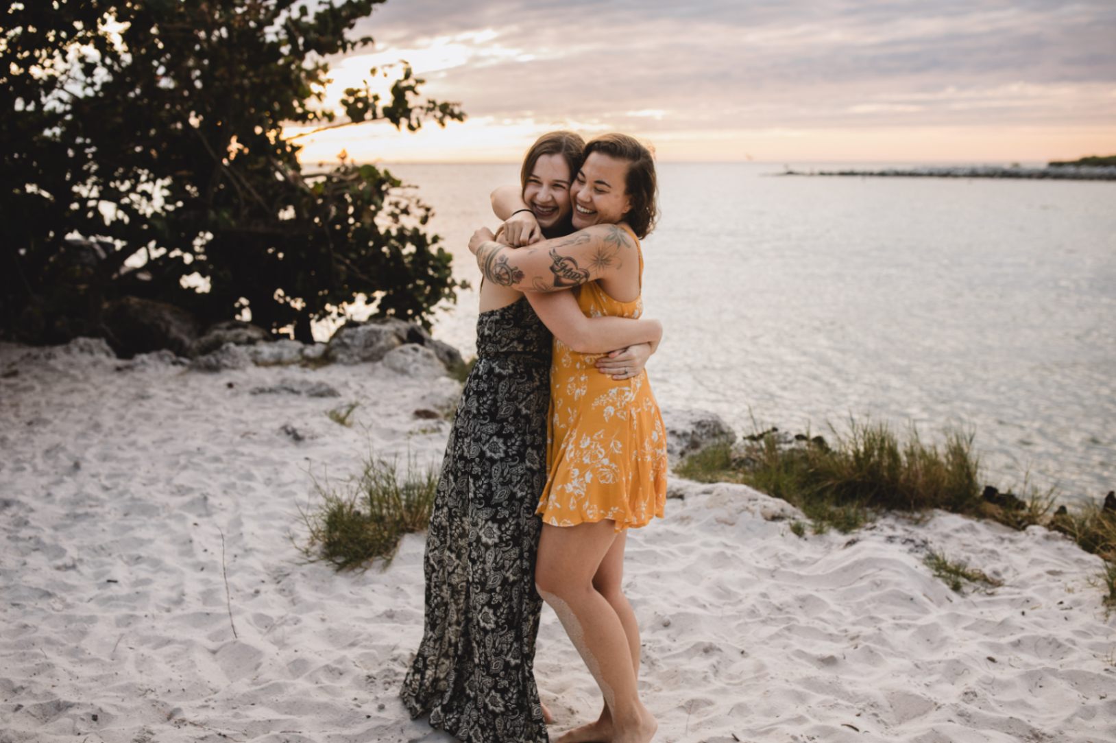 two women in love hug each other on the beach after getting engaged