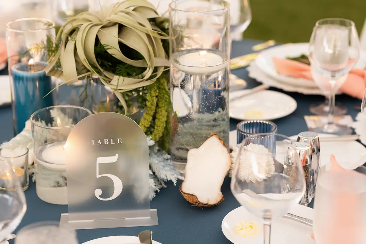 beach wedding table decor with slate blue table cloth and coral napkins