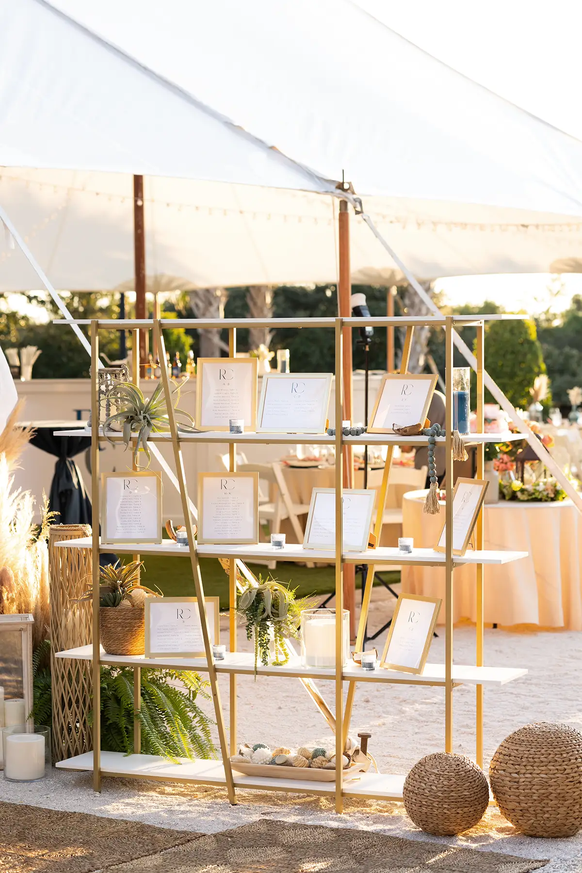 white and wood shelving with seating chart in frames at wedding reception