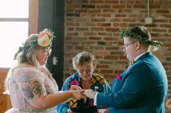 Lesbian wedding ceremony photo of two brides exchanging wedding rings