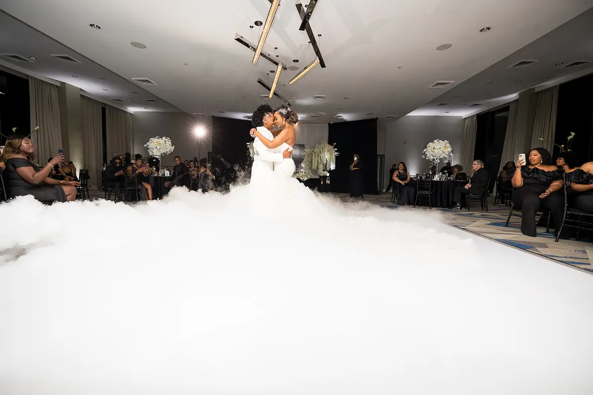 Two Black brides dancing in dramatic cloud effect at Atlanta lesbian wedding reception