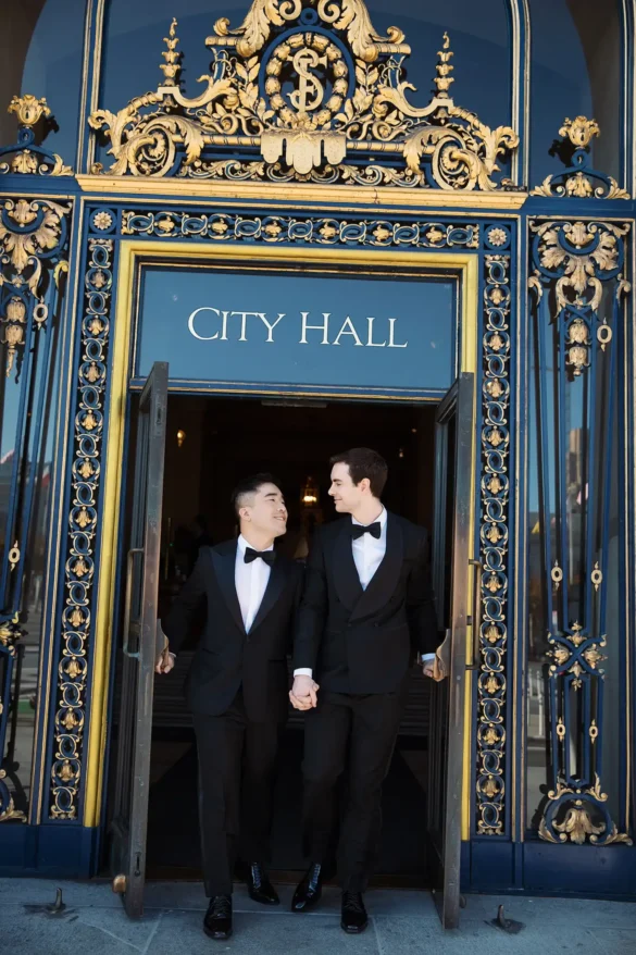 Newlywed grooms Frankie and Ryan walking out of San Francisco City Hall with hands held after their gay wedding.