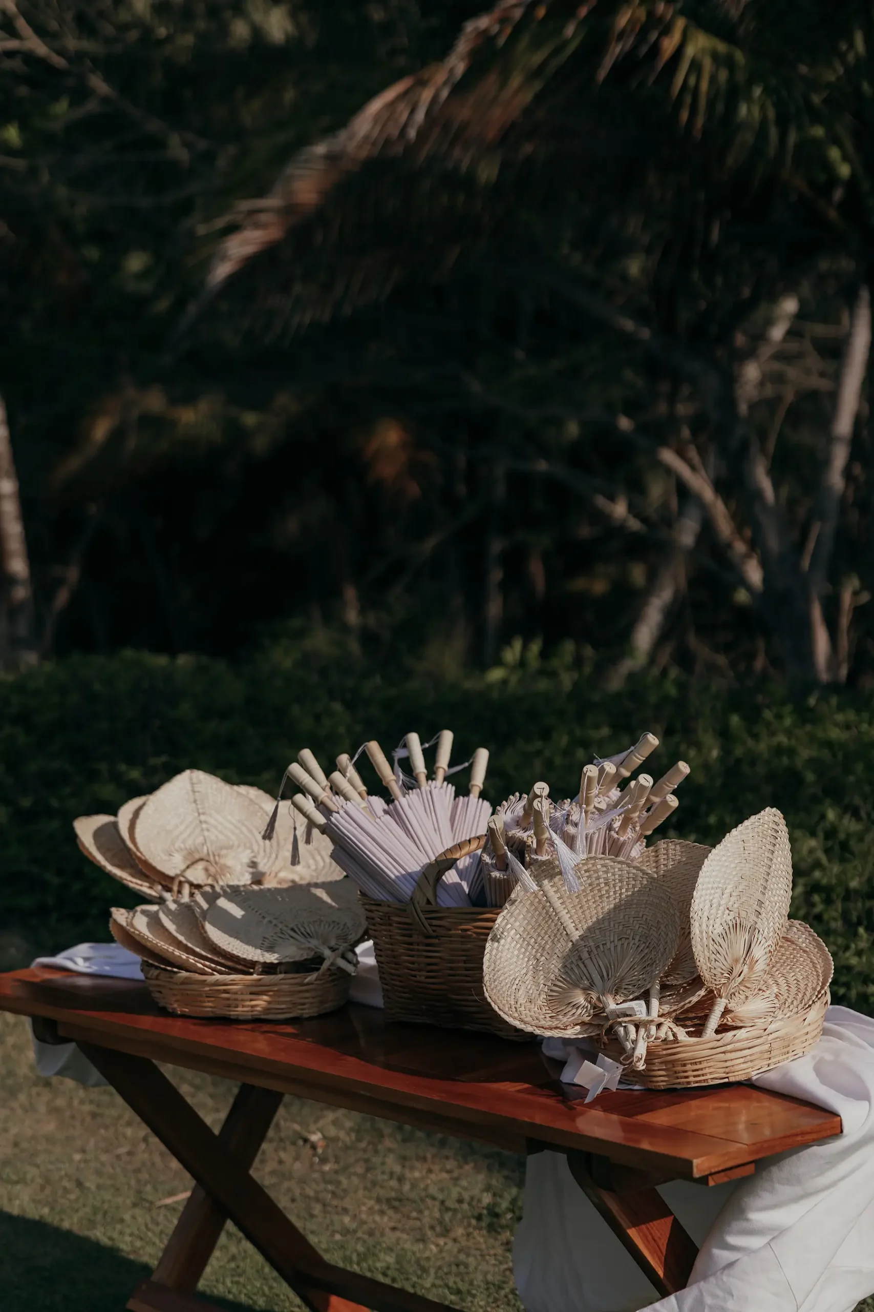 table with fans and umbrellas for guests in outdoor wedding