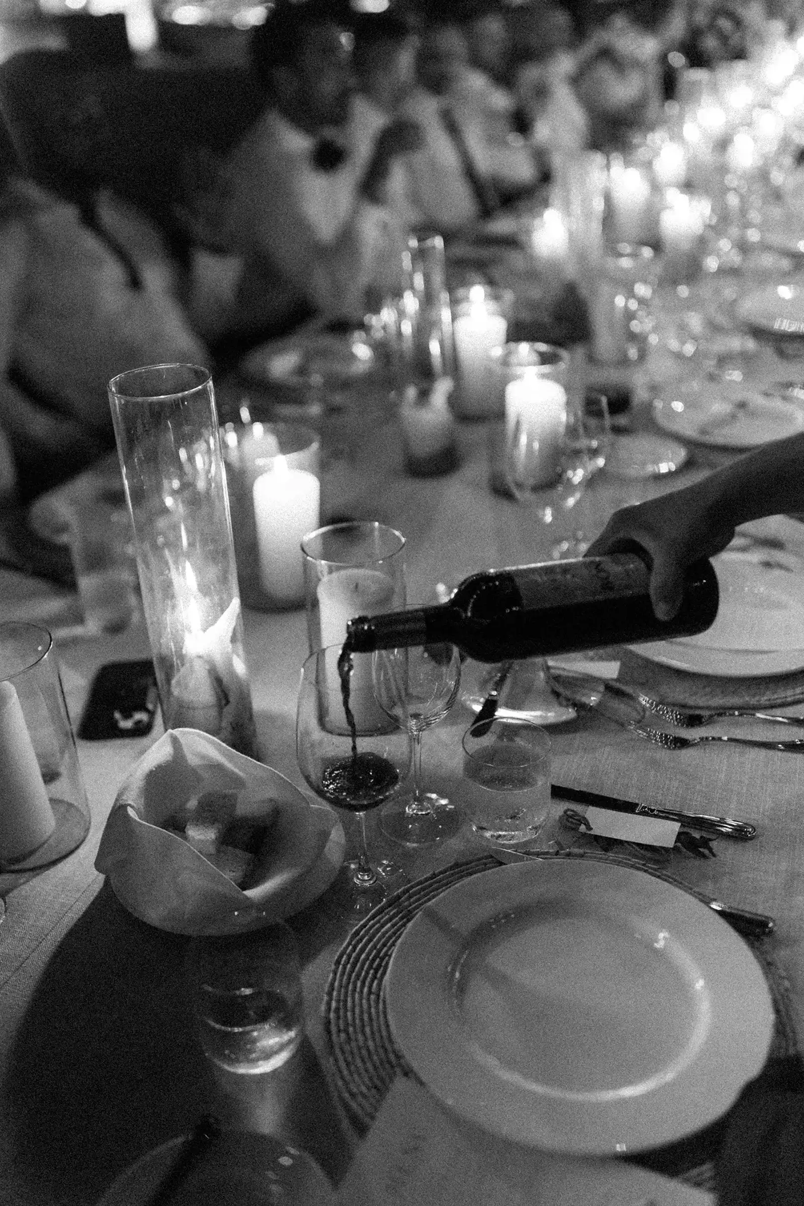 Black and white photo of reception table with candles and guests at Four Seasons Tamarindo wedding in Mexico