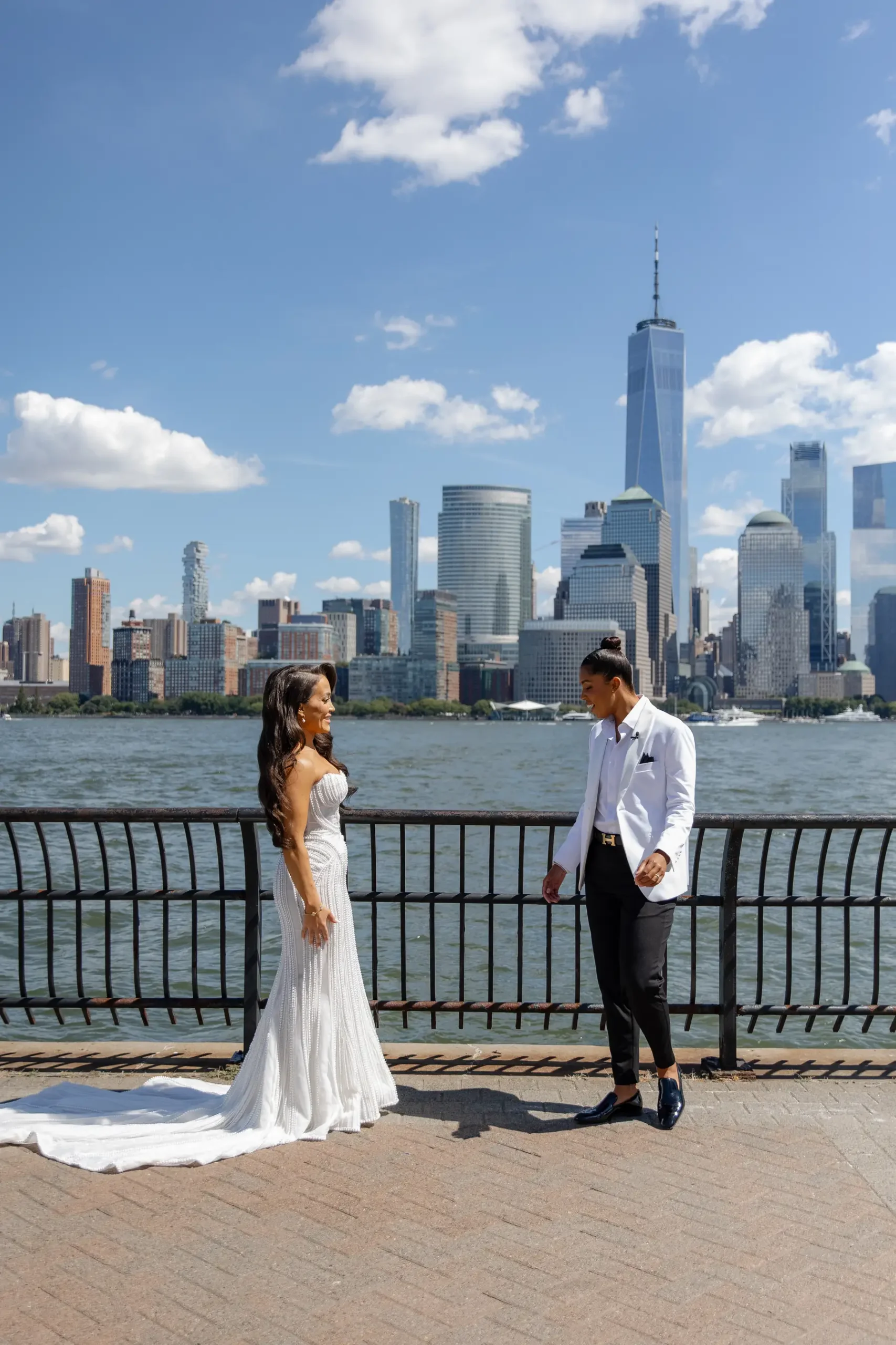 Katherine and Michelle share a first look on the Hudson River waterfront with the Manhattan skyline behind them.