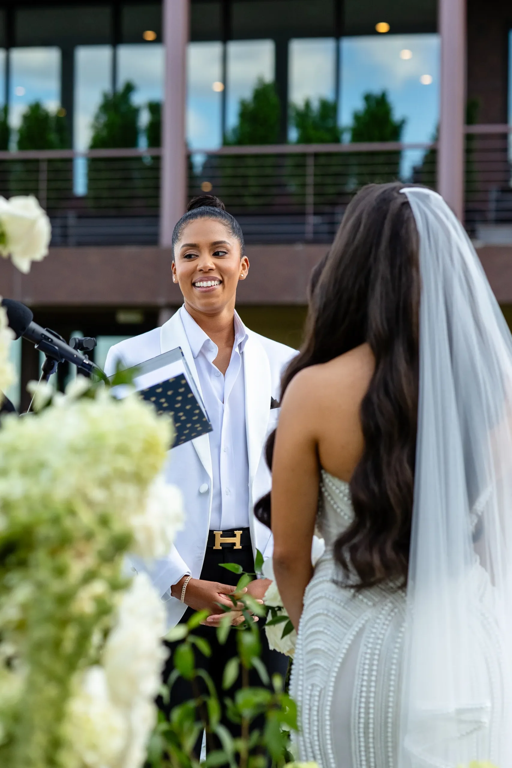 Katherine smiles at Michelle during their outdoor wedding ceremony at Hudson House in Jersey City, N.J.