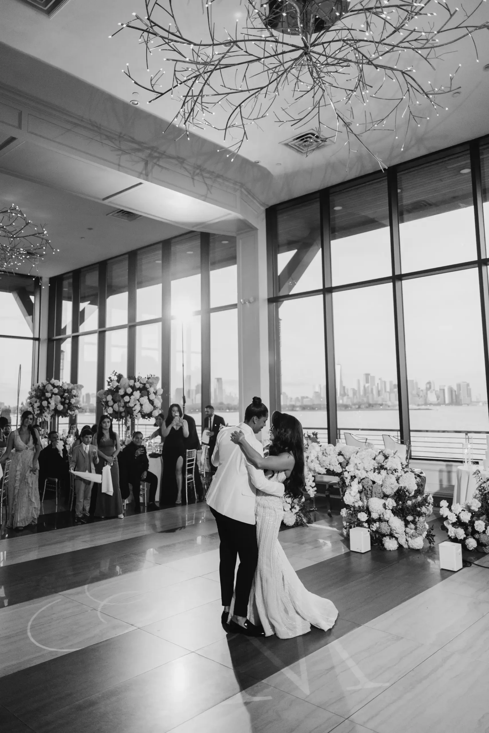 Katherine and Michelle share their first dance at Hudson House in Jersey City, NJ, with the Manhattan skyline glowing behind them.