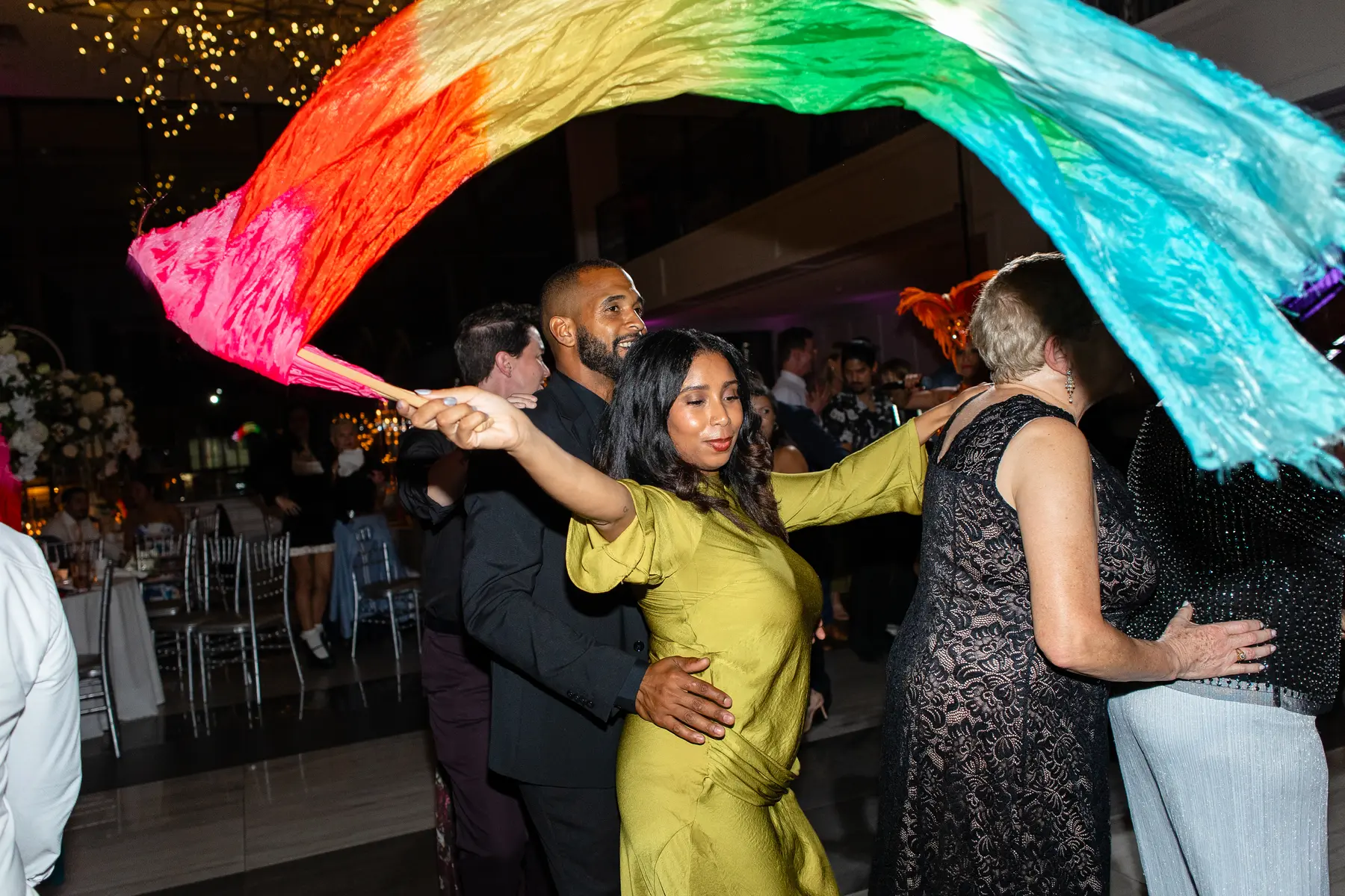 Guests dance under a rainbow silk flag at Katherine and Michelle's wedding reception at Hudson House in Jersey City.