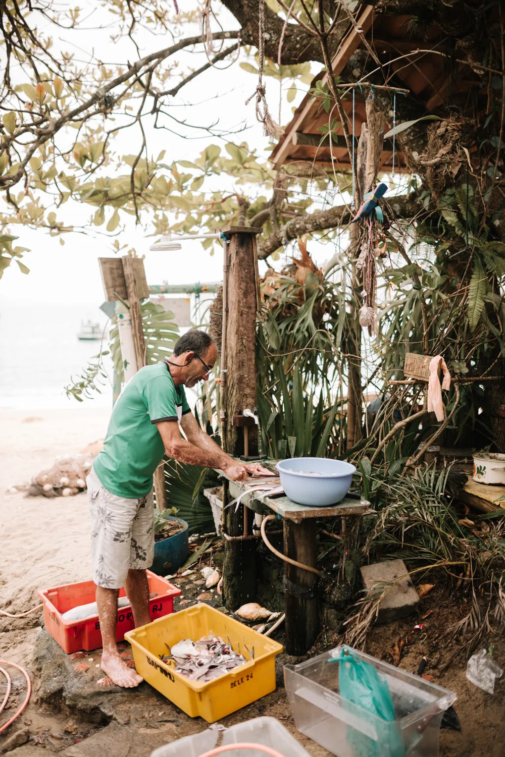 A fisherman cleans fresh fish at an outdoor station near the beach at Pouso das Flores in Paraty, Brazil.
