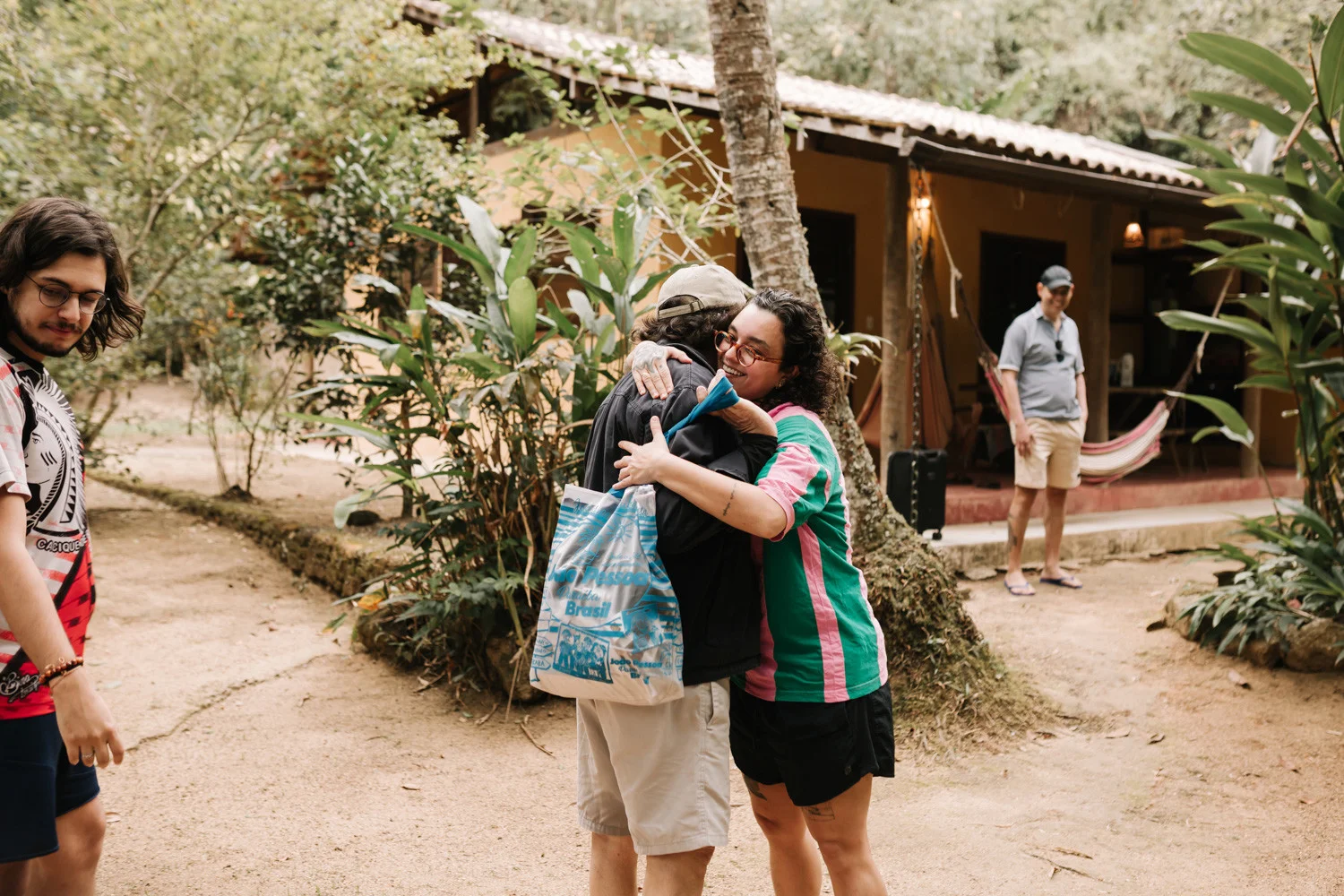 Rafaela and Nathalia share a warm hug outdoors at Pouso das Flores in Paraty, Brazil.