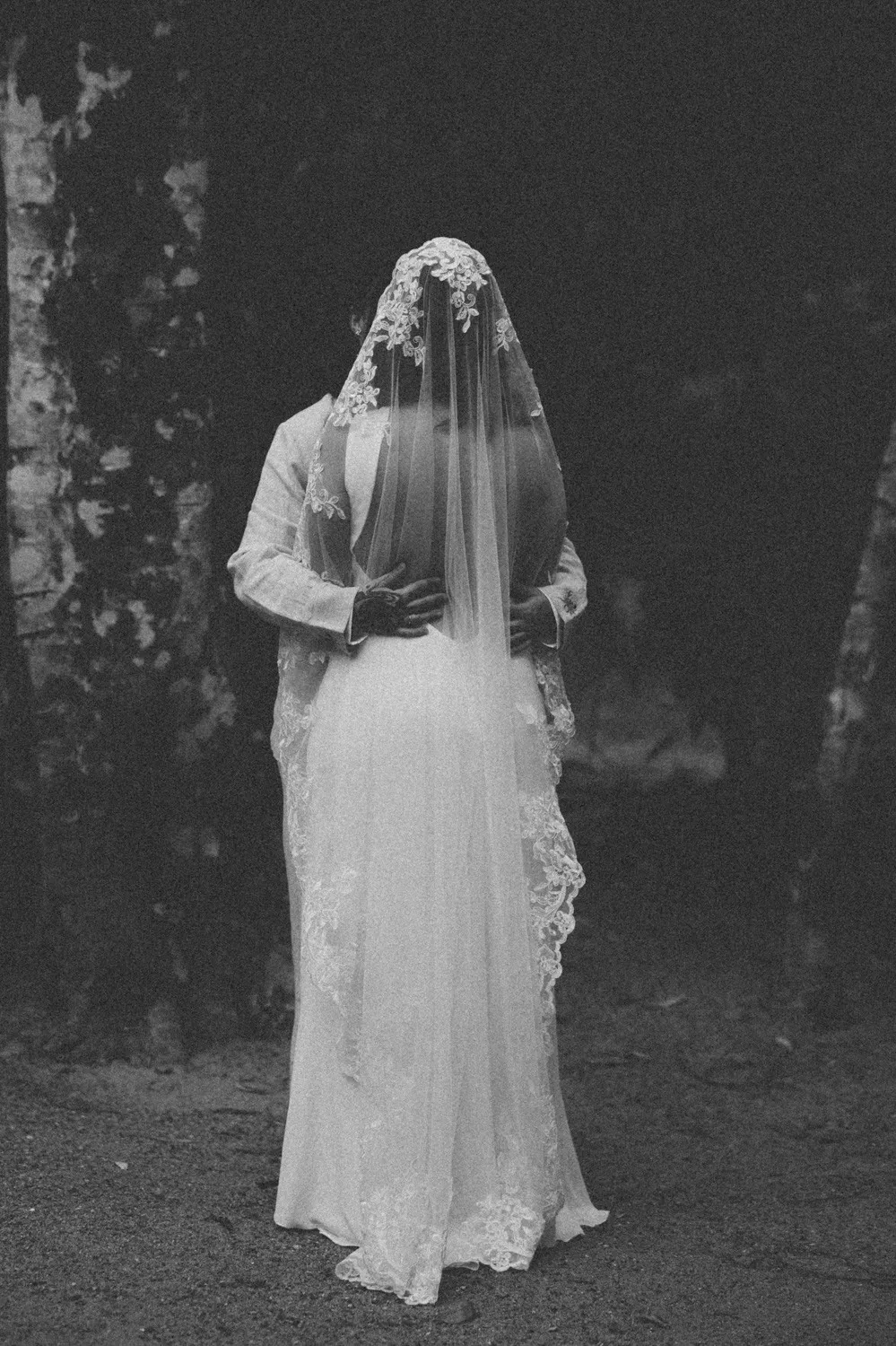 Rafaela and Nathalia embrace from behind at Pouso das Flores in Paraty, Brazil, in a black-and-white film photo.