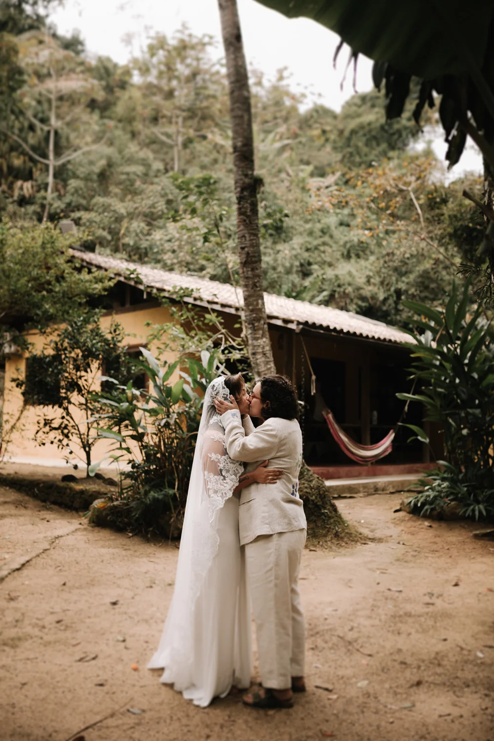Rafaela and Nathalia share their first kiss as newlyweds outdoors at Pouso das Flores in Paraty, Brazil.