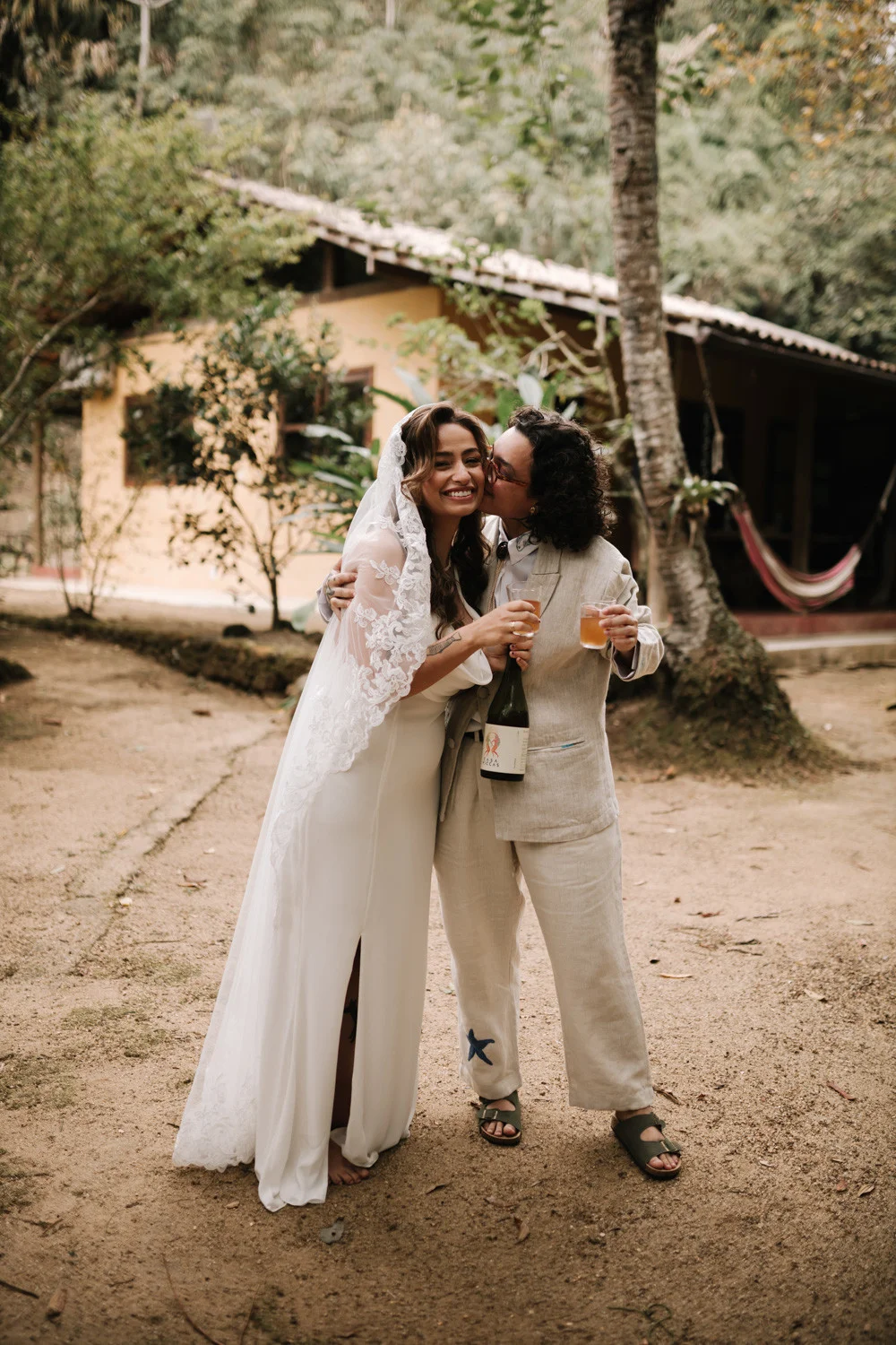 Rafaela and Nathalia embrace and share champagne outside Pouso das Flores in Paraty, Brazil.