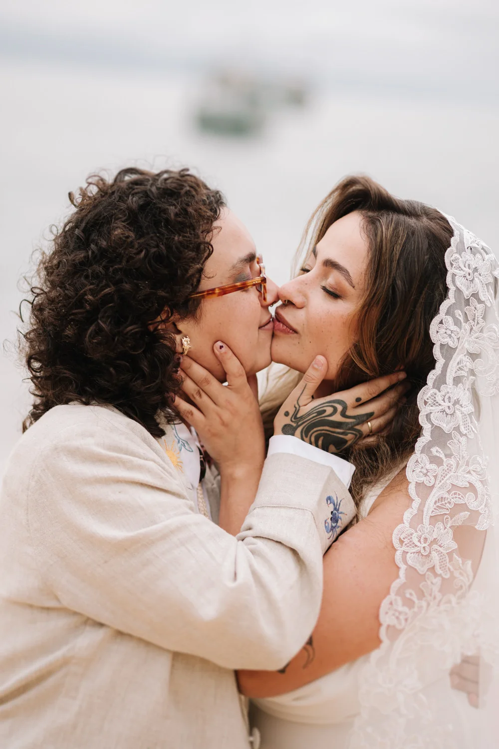 Rafaela and Nathalia share a tender kiss at Pouso das Flores in Paraty, Brazil, framed by a lace veil.