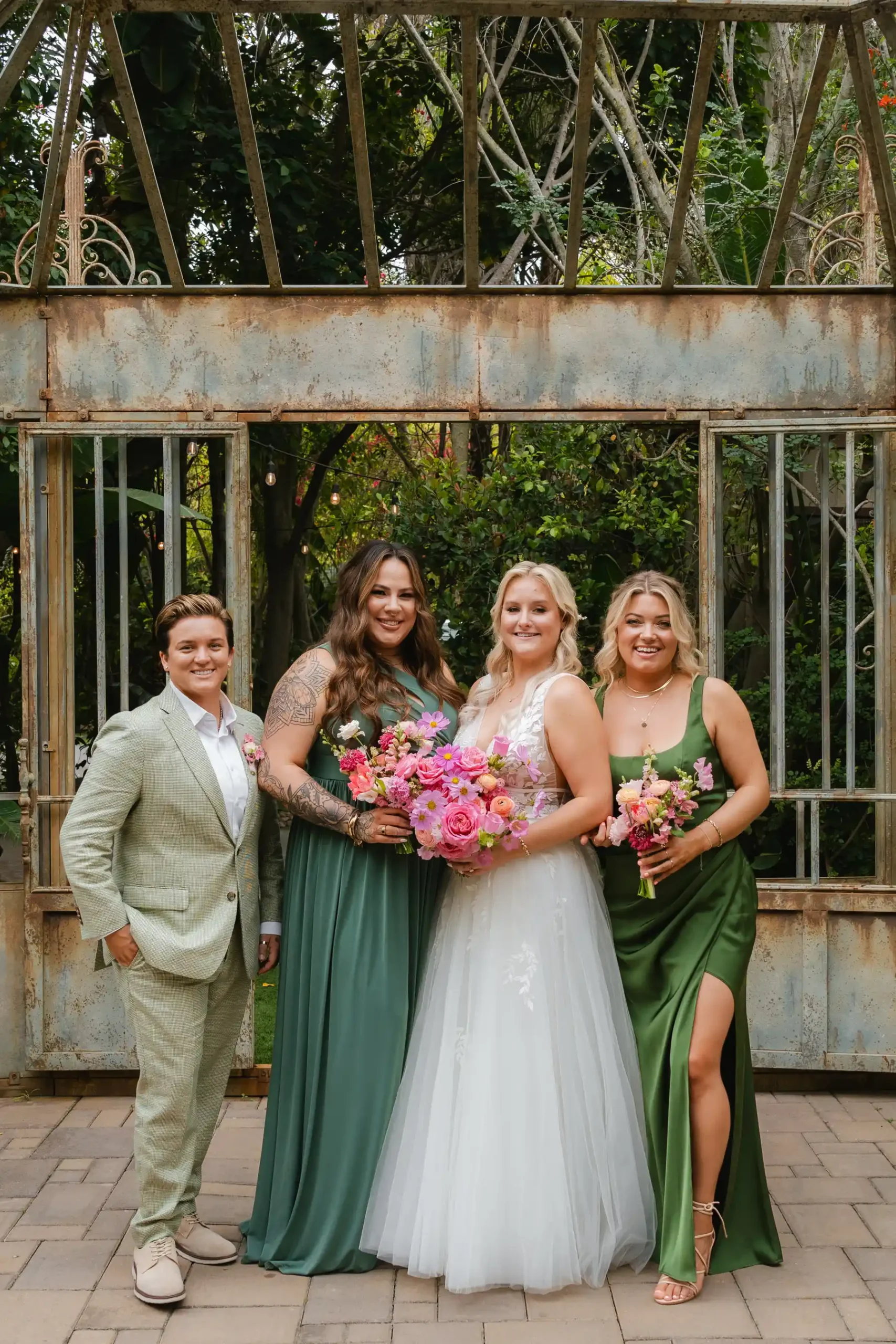 Bride Erika Beursken with wedding party in green gowns and sage suit at Botanica in Oceanside, California.
