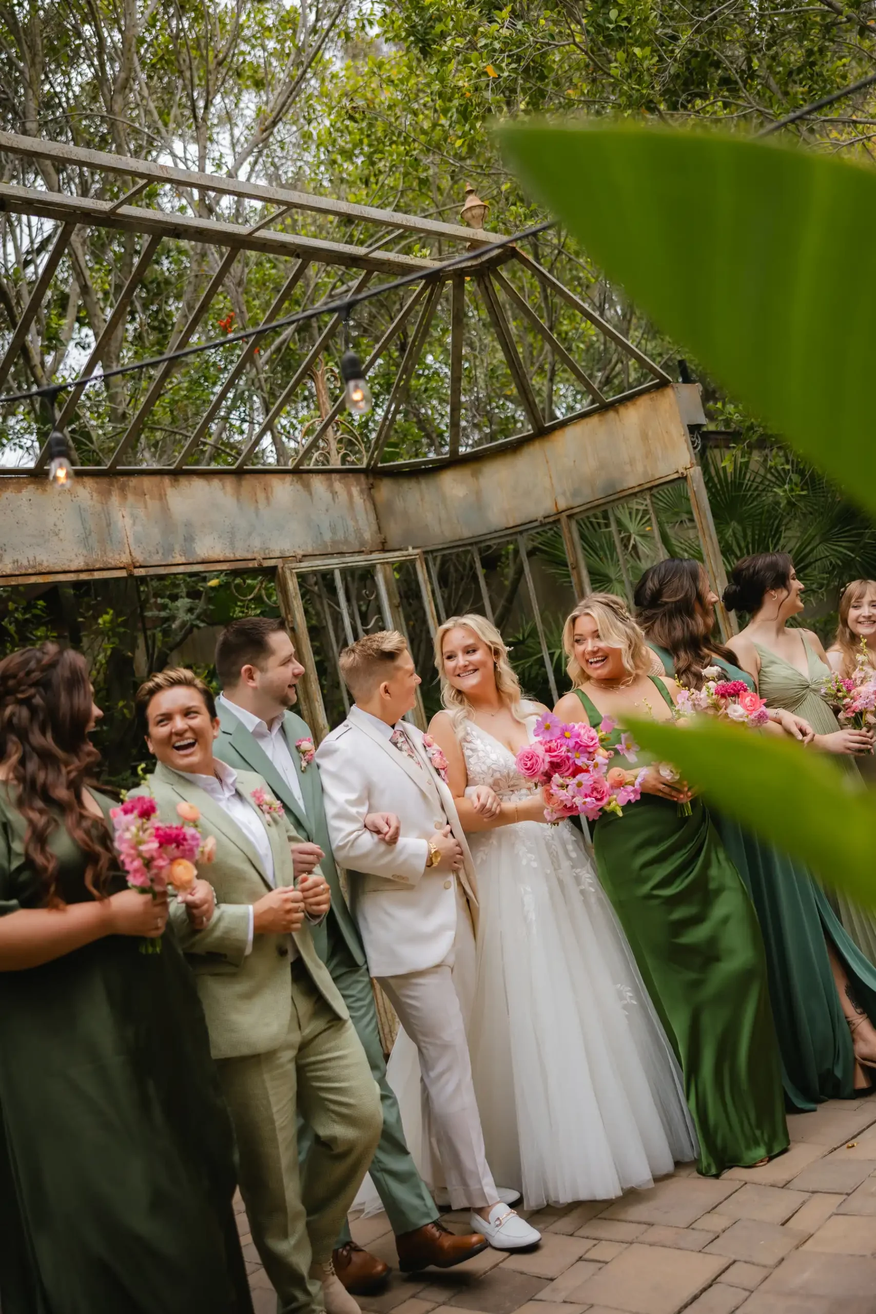 Erika Beursken and Melissa Brodsky laugh with their wedding party at Botanica in Oceanside, California.