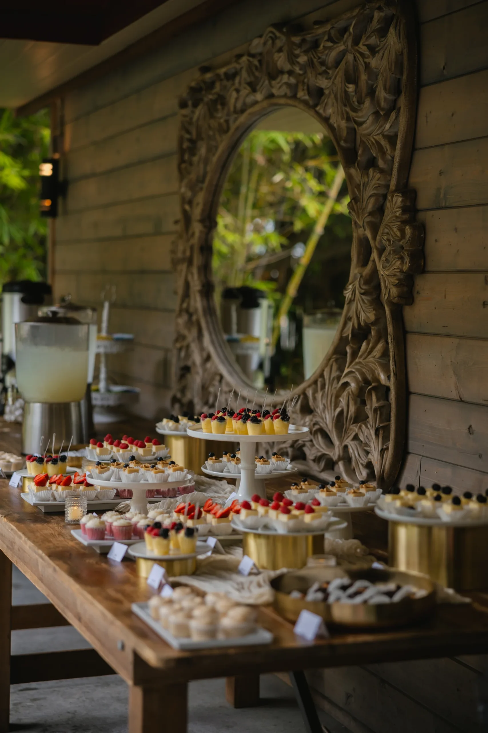Elegant dessert table with berry-topped cupcakes and mini cheesecakes at Botanica in Oceanside, California.