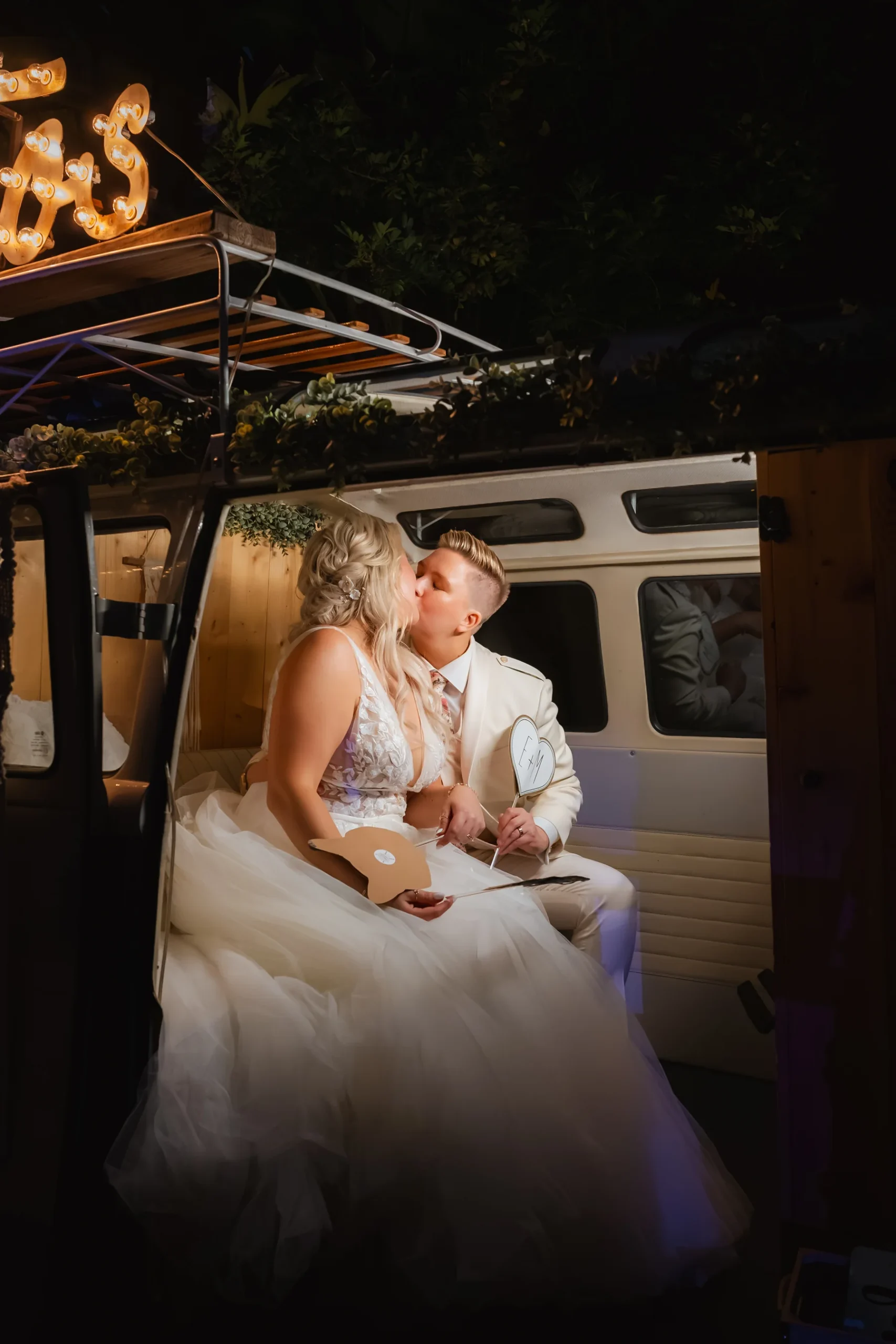 Erika Beursken and Melissa Brodsky share a kiss inside a vintage VW van photo booth at Botanica in Oceanside, California.