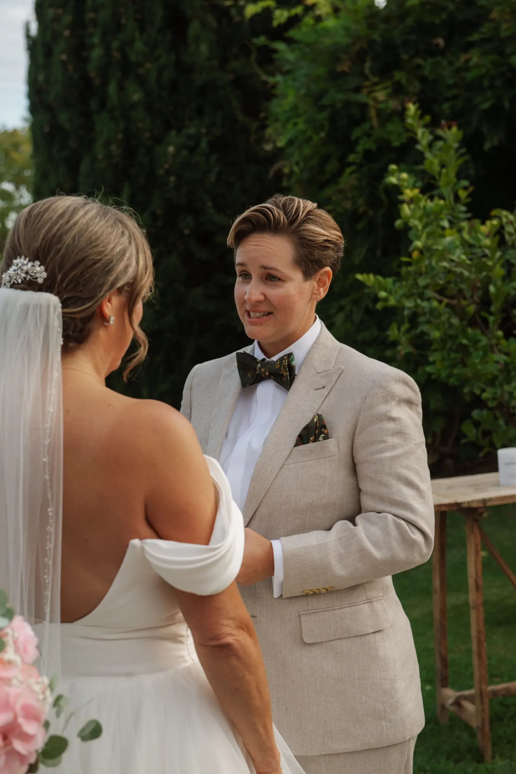 Jasmine Shimerda smiles at Lauren Thomas during their outdoor wedding ceremony at Casa Cornacchi in Arezzo, Tuscany.