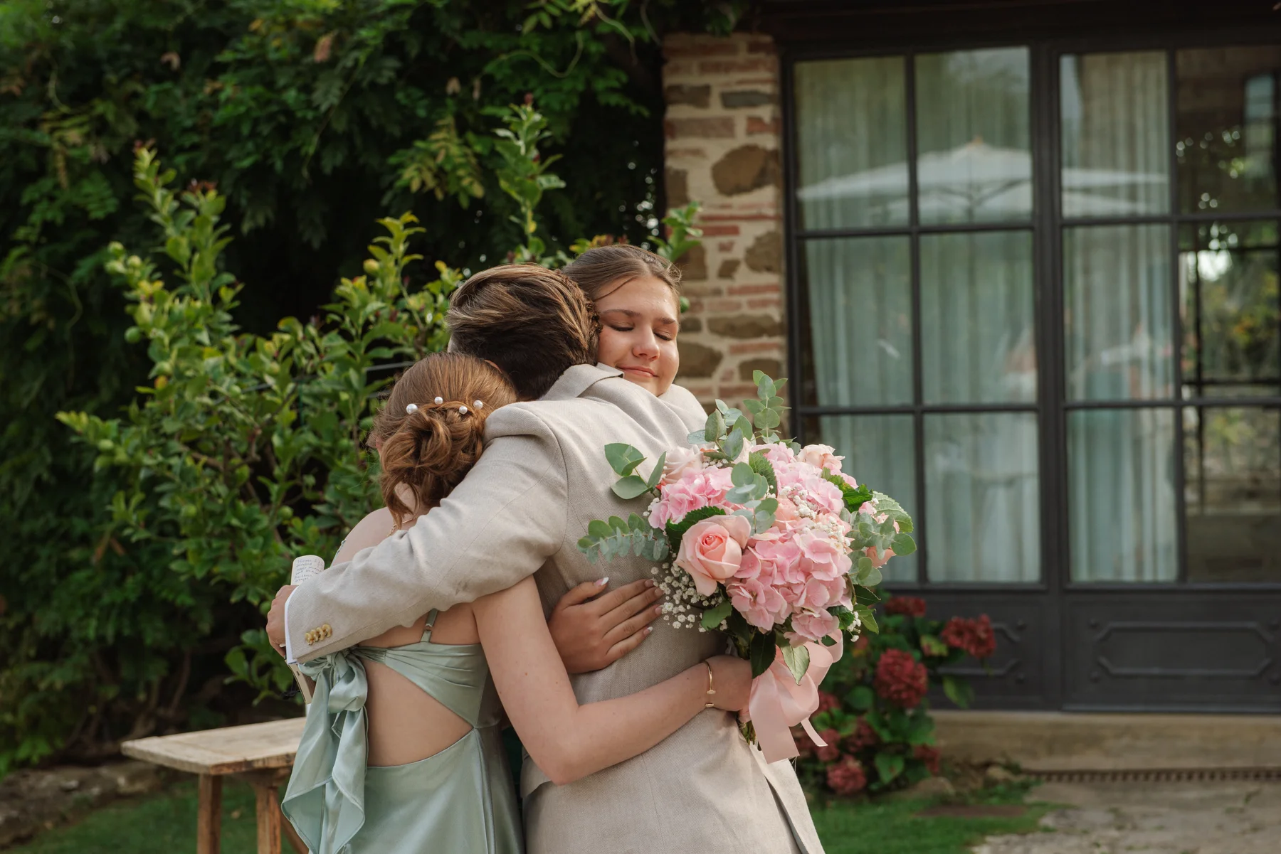 Lauren Thomas and Jasmine Shimerda share a group hug with a guest at Casa Cornacchi in Tuscany, Italy.
