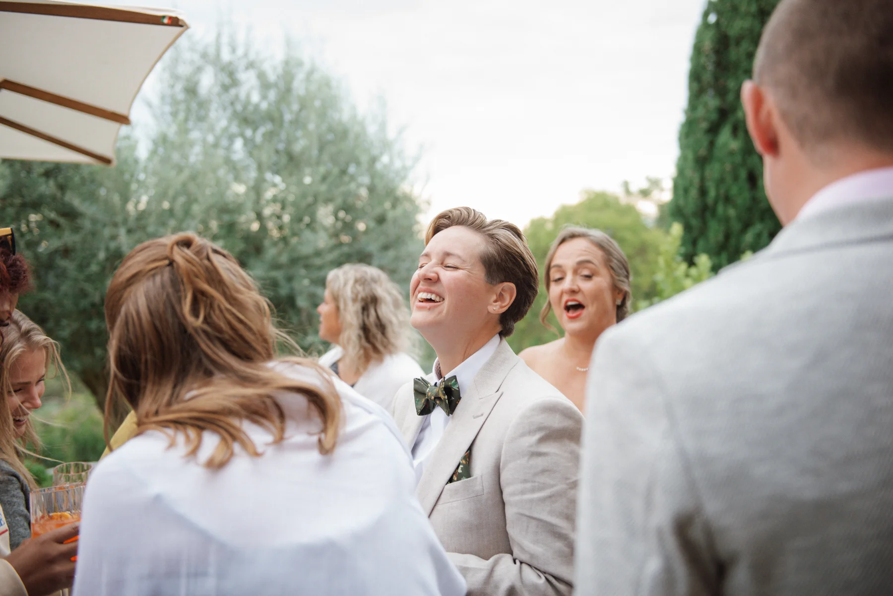 Lauren Thomas laughs joyfully with guests during the reception at Casa Cornacchi in Arezzo, Tuscany, Italy.