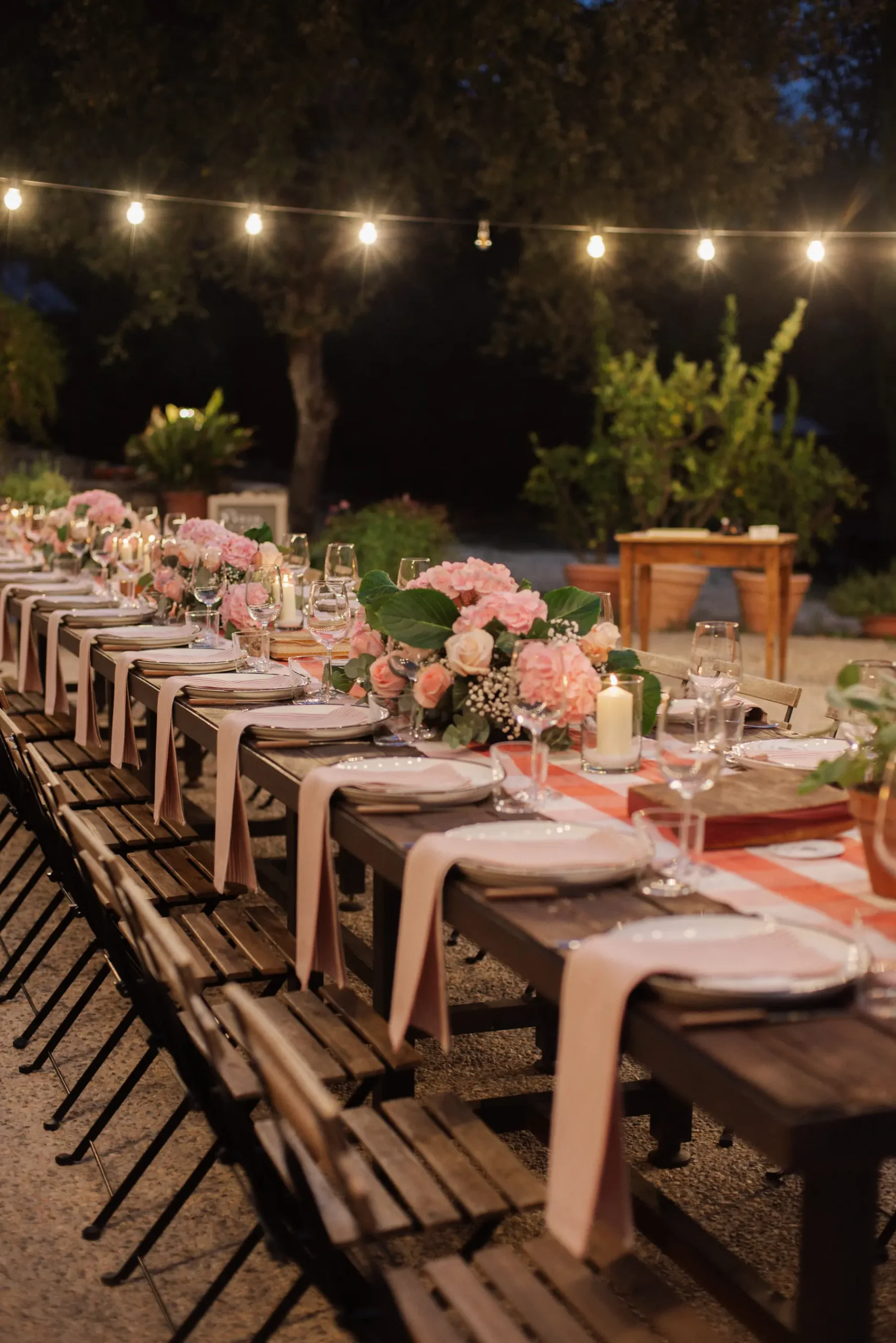 Candlelit outdoor reception tablescape at Casa Cornacchi in Arezzo, Tuscany, adorned with pink florals and string lights.