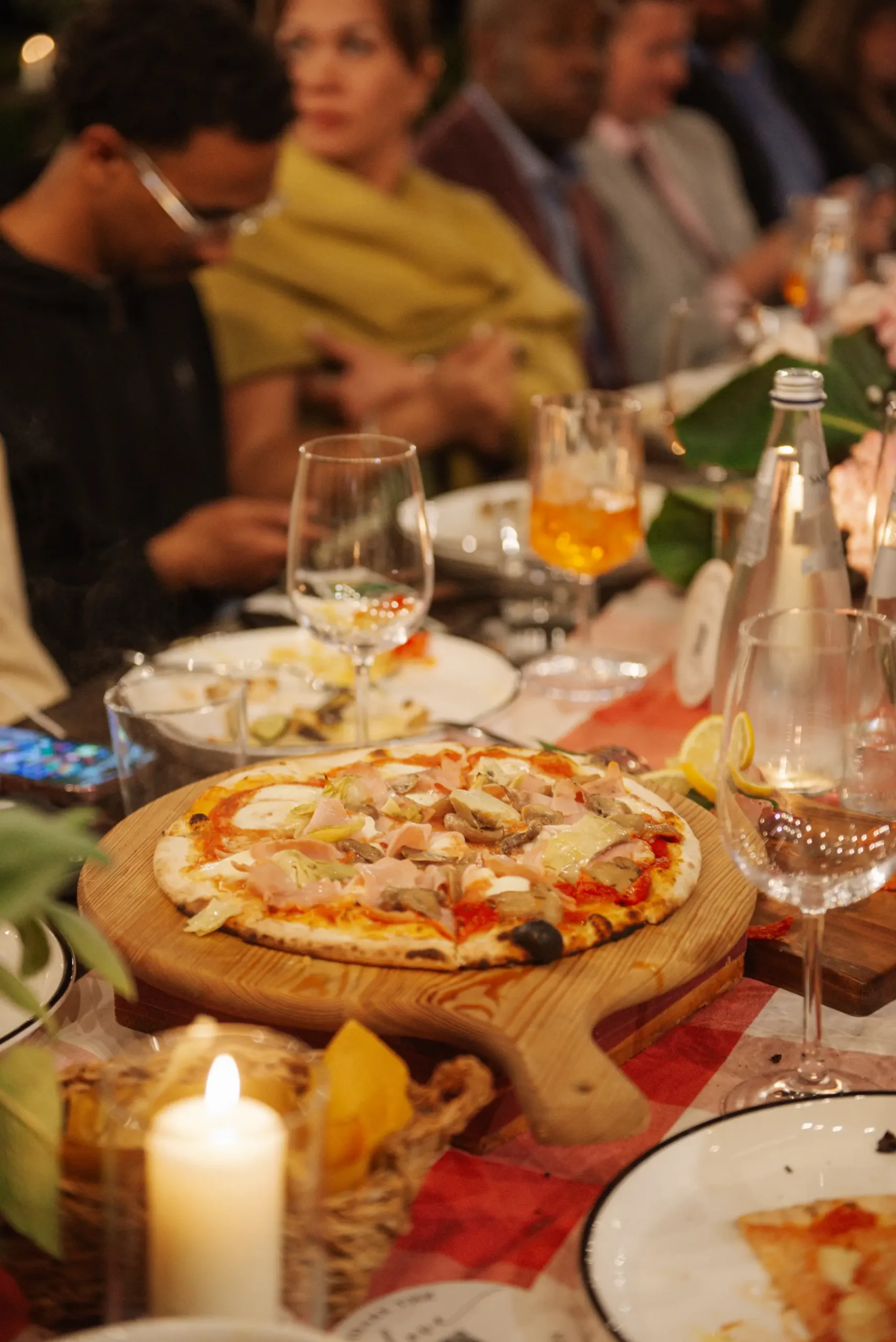 A wood-board pizza with ham and artichokes at Lauren and Jasmine's candlelit reception dinner at Casa Cornacchi in Tuscany.