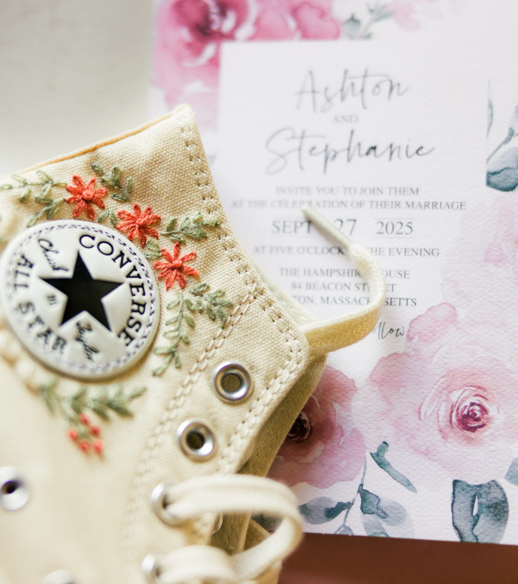 Embroidered Converse sneaker beside a floral wedding invitation for Ashton and Stephanie at Hampshire House, Boston.