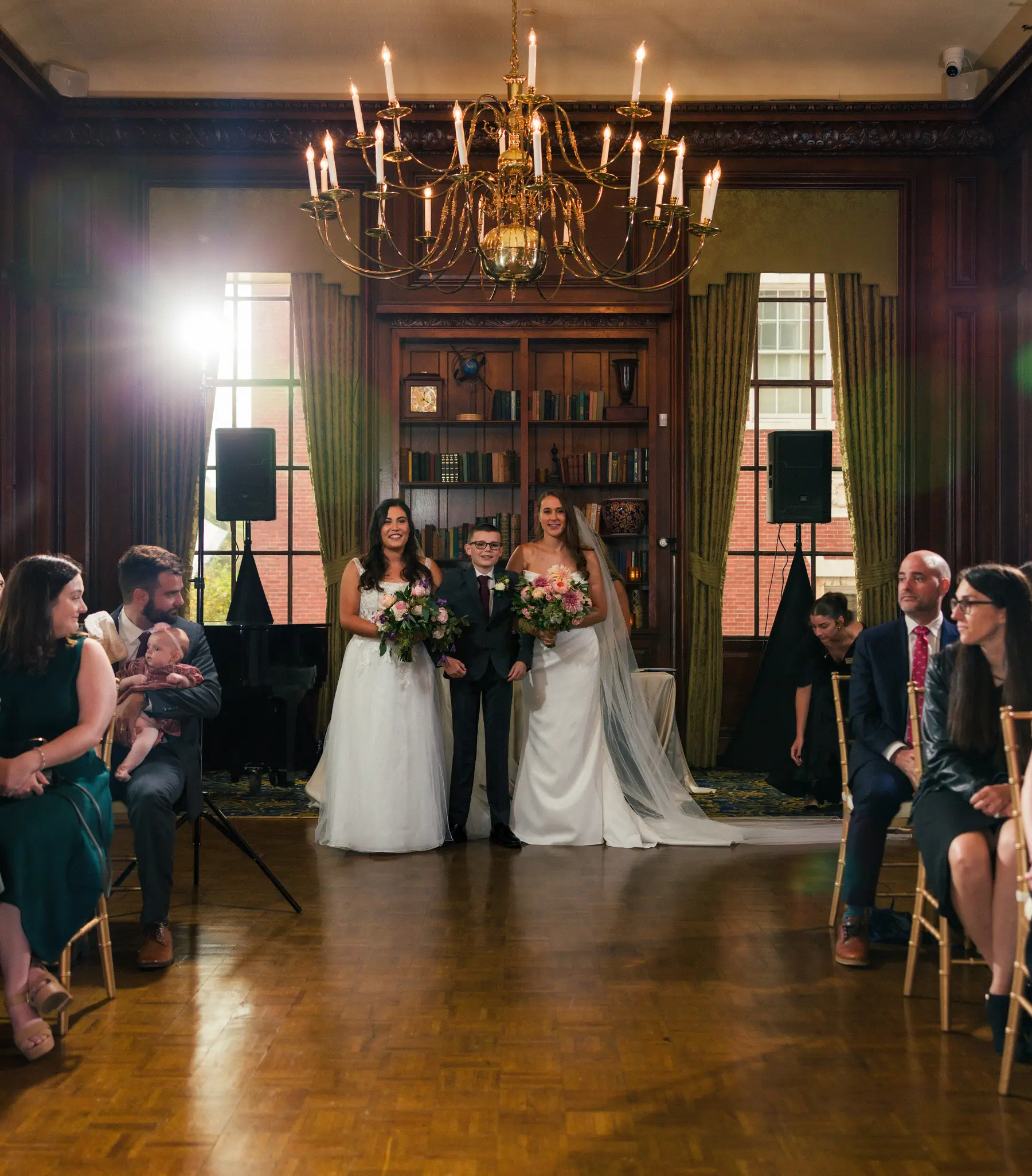 Brides Ashton Hattori and Stephanie Tillman walk the aisle with a young escort at Hampshire House in Boston.