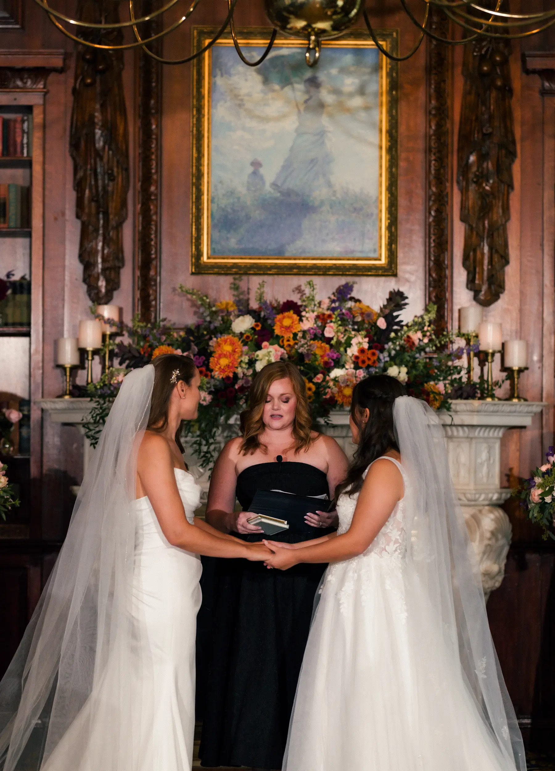 Brides Ashton Hattori and Stephanie Tillman hold hands during their ceremony at Hampshire House in Boston.