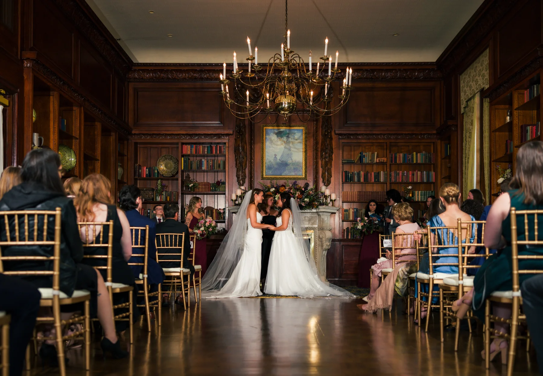 Ashton Hattori and Stephanie Tillman exchange vows at Hampshire House in Boston, MA, surrounded by guests in a wood-paneled library.
