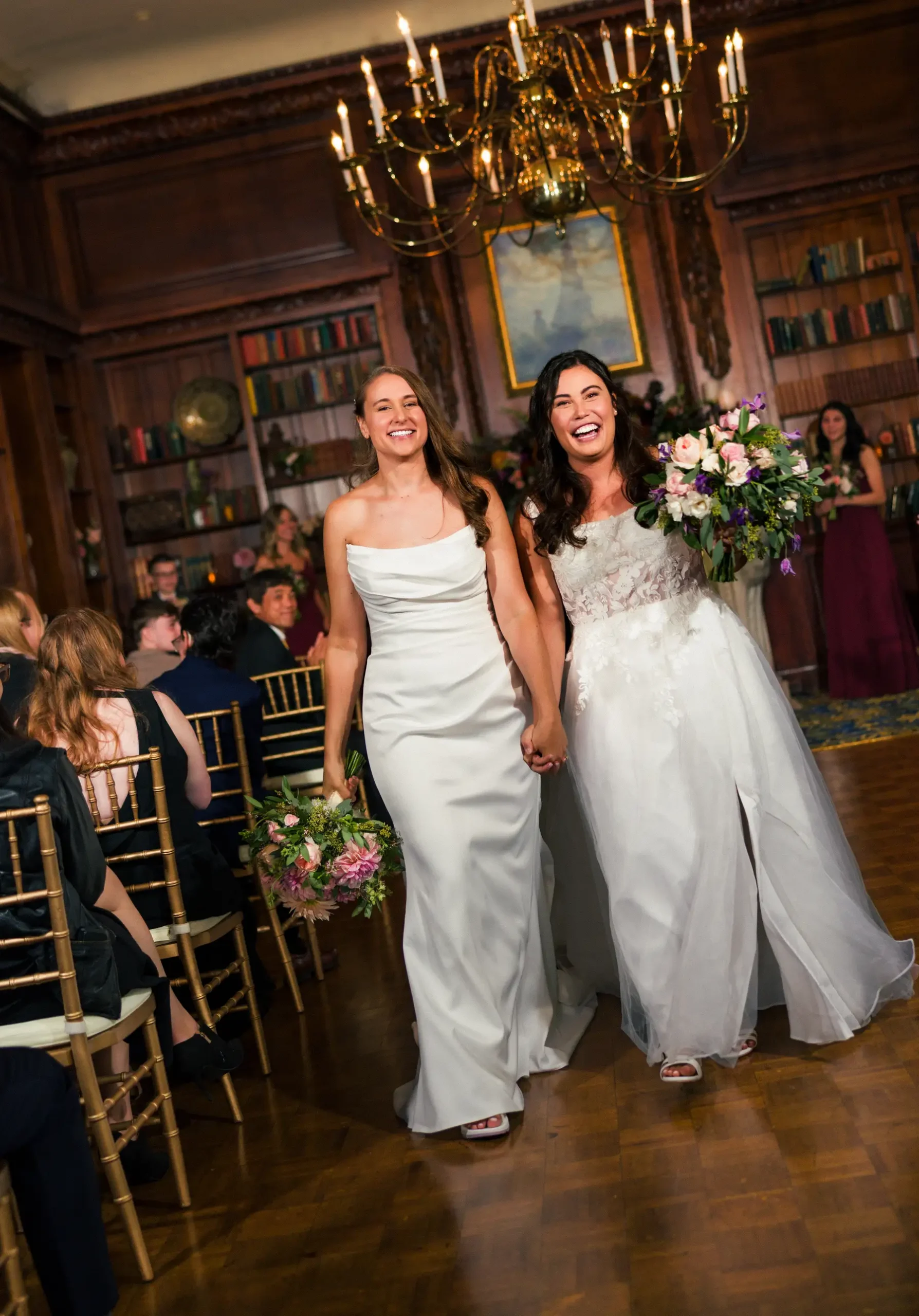 Brides Ashton Hattori and Stephanie Tillman walk the aisle hand in hand at Hampshire House in Boston, MA.