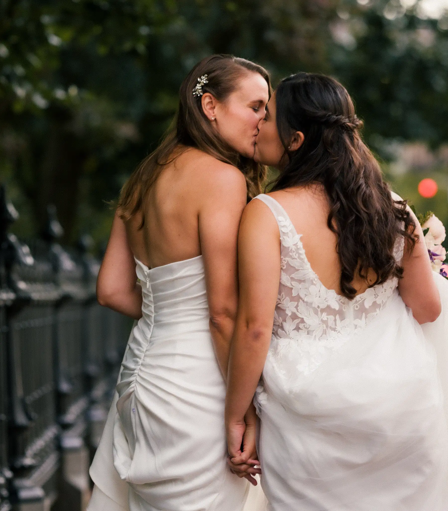 Brides Ashton Hattori and Stephanie Tillman share a kiss in white wedding gowns at Hampshire House in Boston.