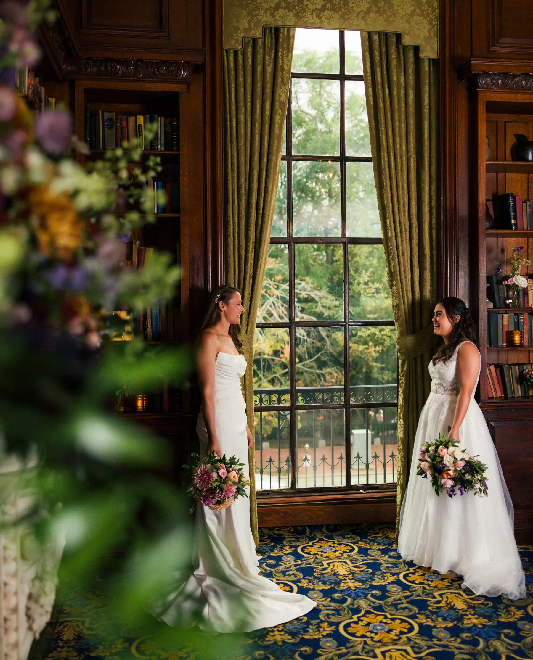 Brides Ashton Hattori and Stephanie Tillman smile at each other in white gowns at Hampshire House, Boston.